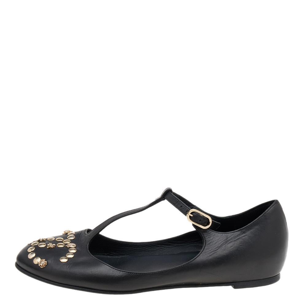 Walk with style and panache in these ballet flats from the House of Chanel. They are made from black leather, with an embellished CC logo adorning the front. These ballet flats are highlighted with a T-strap, buckle closure, and gold-tone hardware.