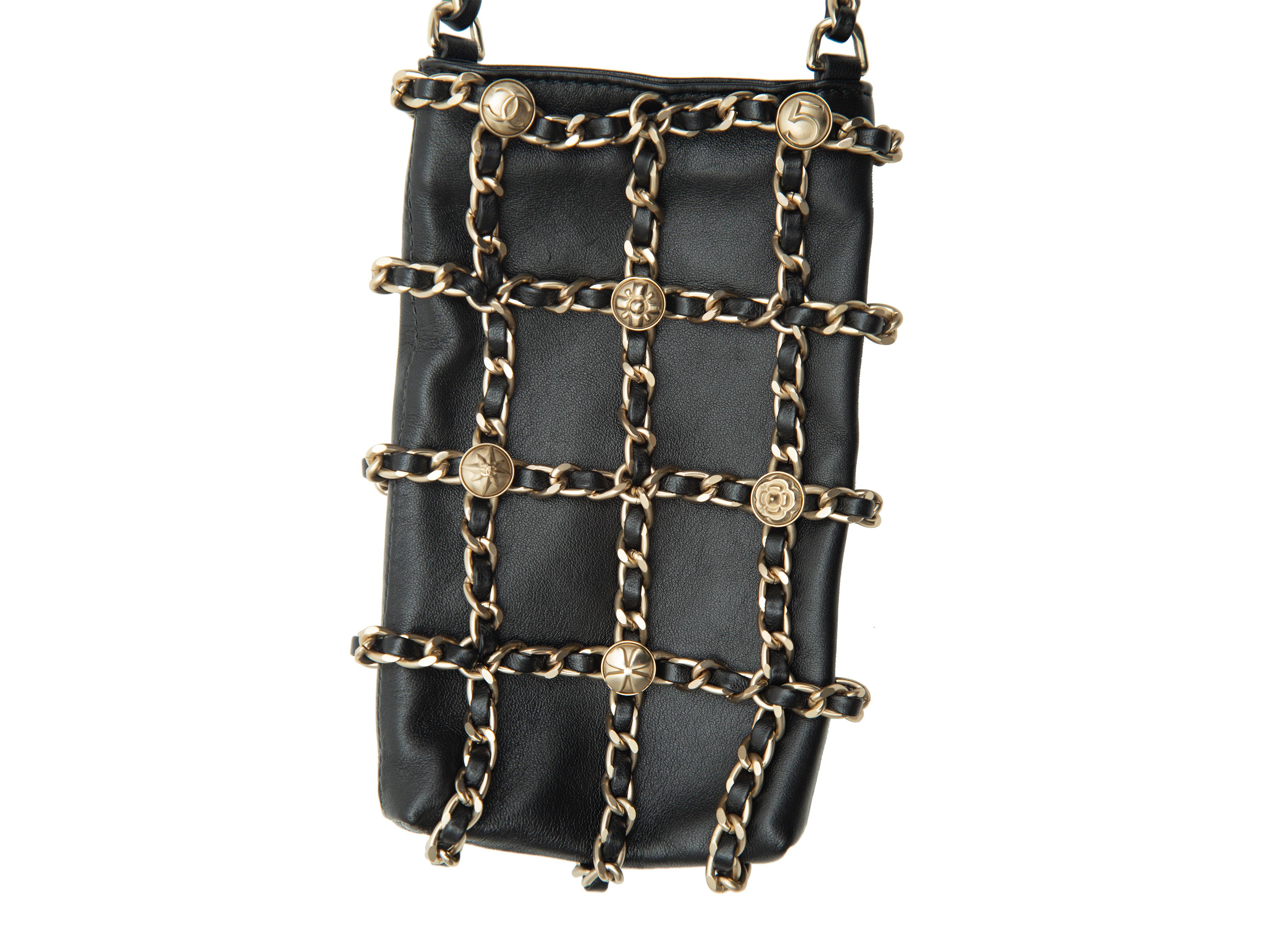 Product details: Black leather and chain-link crossbody phone bag by Chanel. Gold-tone hardware. Single strap. 4