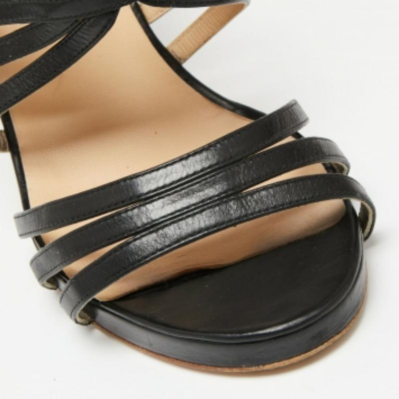 Ces sandales de la maison Chanel sont synonymes de classe et d'élégance ! Elles sont réalisées en cuir noir et présentent des détails à lanières qui rehaussent leur beauté. Ces sandales ont des bouts ouverts, des ferrures dorées et de hauts talons