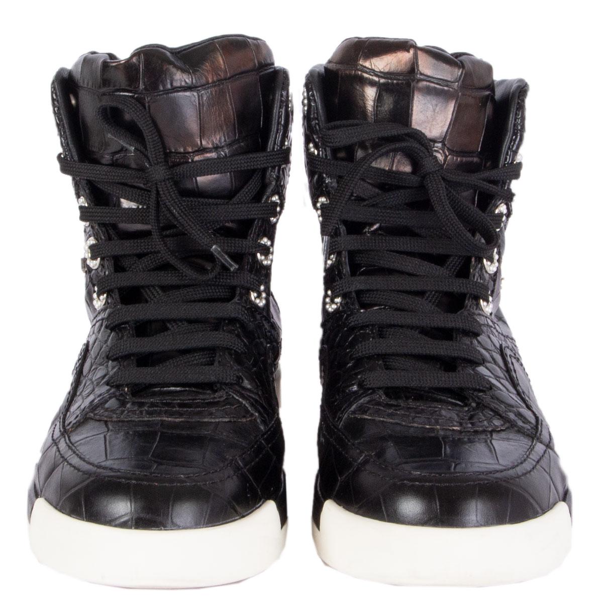 100% authentic Chanel lace-up high-top sneakers in black crocodile embossed leather. Silver accent lettering on the side. Pearl embellished eyelets. Padded shoe tongue and white rubber sole. Have been worn and are in excellent condition. 

Imprinted