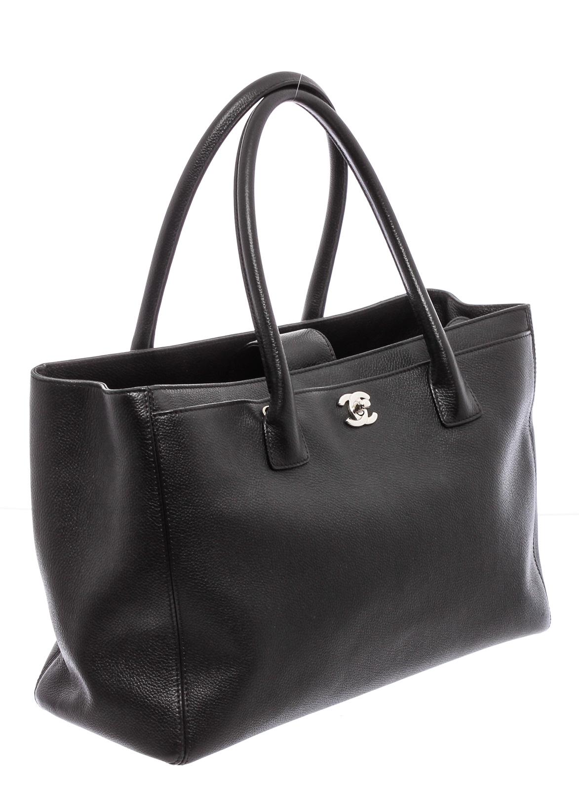 Black Cerf leather Chanel Executive Tote with silver-tone hardware, dual rolled top handle, single detachable flat shoulder strap, protective feet at base, three compartments; one with CC twist-lock closure, one with magnetic snap closure, tonal