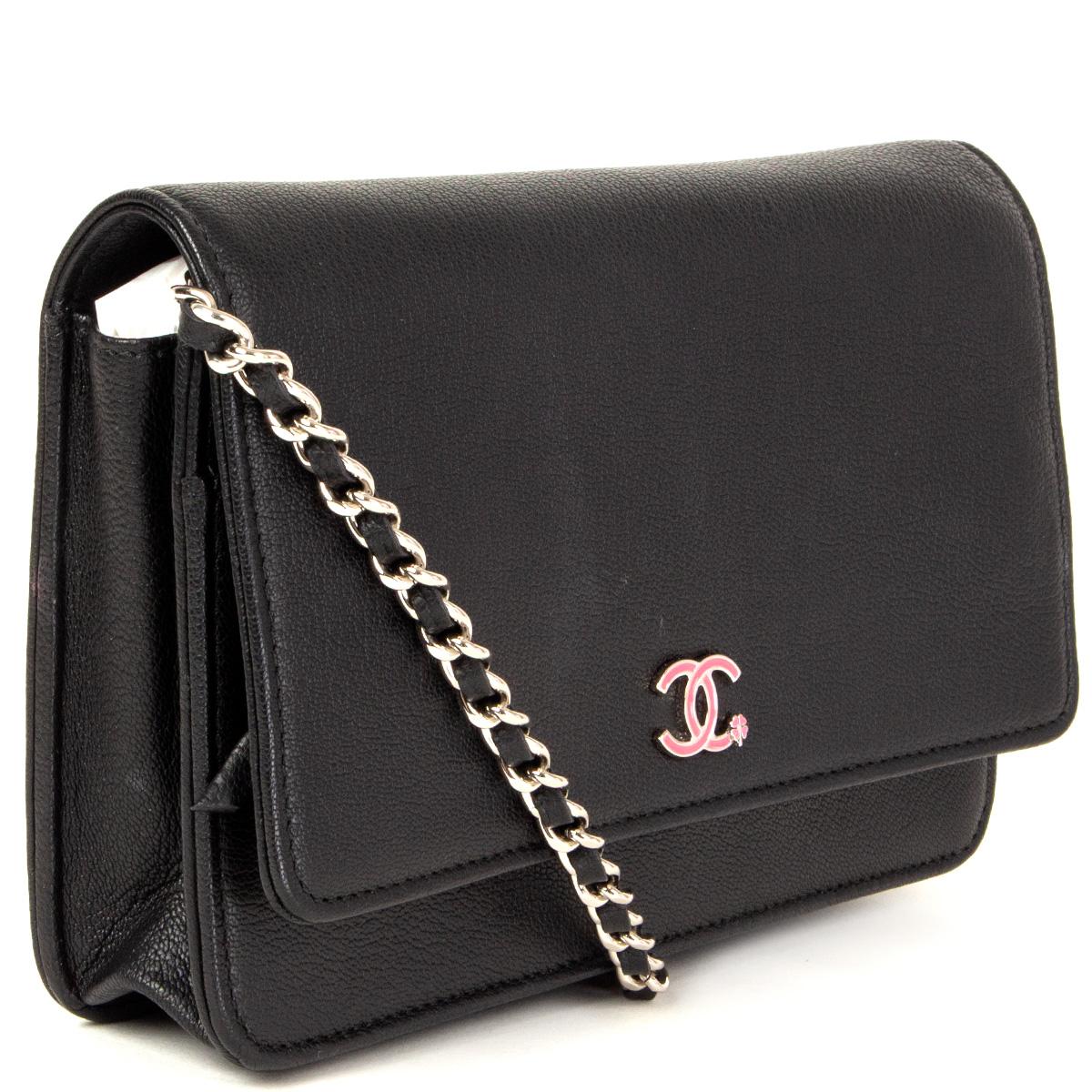 100% authentic Chanel wallet on chain in black leather with pink CC enamel and metal embellishment. Opens with a snap-button. Zipper pocket in the flap and a full-size open and zipper pocket on the front. Lined in multicolor floral fabric with an
