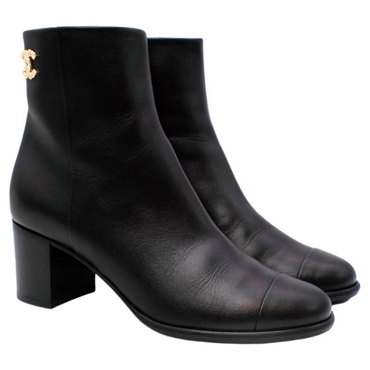 Chanel Black Leather Gold-Tone CC Logo Heeled Ankle Boots

- Smooth black leather 
- Textured gold-tone metal CC logo adorns the ankle 
- Round toe 
- Side zip closure fastening 
- Set on a low block heel

Materials 
100% Leather 
100% Gold tone