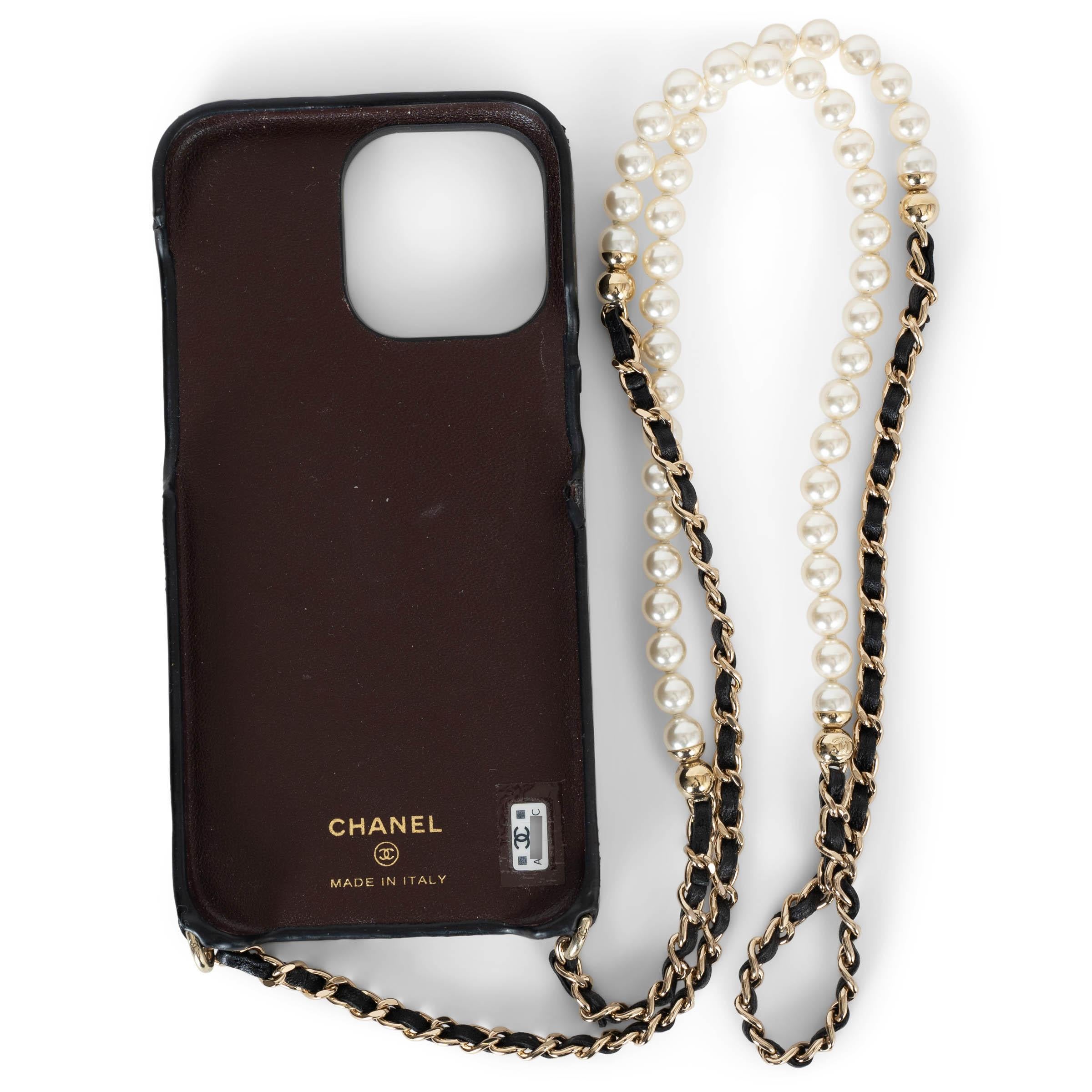 This 100% authentic Chanel iPhone 13 Pro Max case in black quilted lambskin leather is the epitome of luxury and functionality. Featuring a gold-tone CC logo, it is adorned with a signature black leather-interwoven gold-tone chain and a strand of