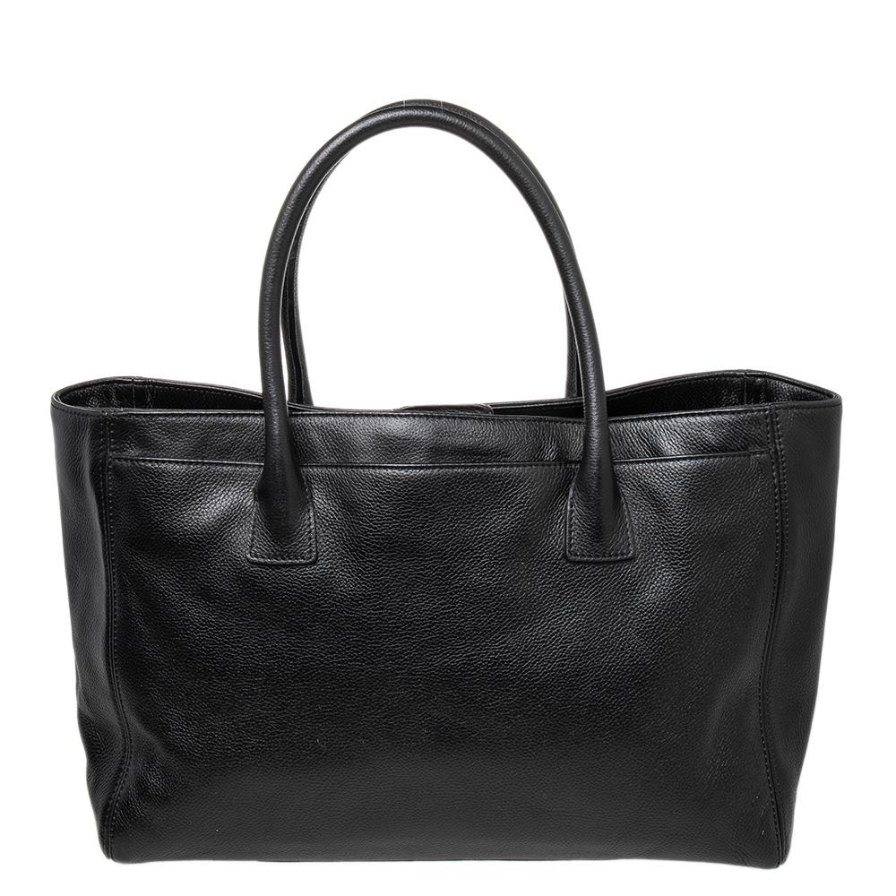This Cerf tote from Chanel is a perfect blend of practicality and style. It features a black leather construction that is enhanced with a silver-tone CC logo on the front and dual top handles. It is equipped with a spacious fabric and leather-lined