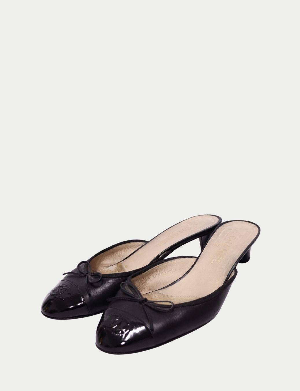 Chanel Schwarze Leder Pantoletten - CC Cap Toe Slip-On Heels

Zeitlose Eleganz mit diesen schwarzen Lederpantoletten von Chanel, ein klassisches und raffiniertes Design, das sowohl für den Tag als auch für den Abend geeignet ist.

Die aus schwarzem