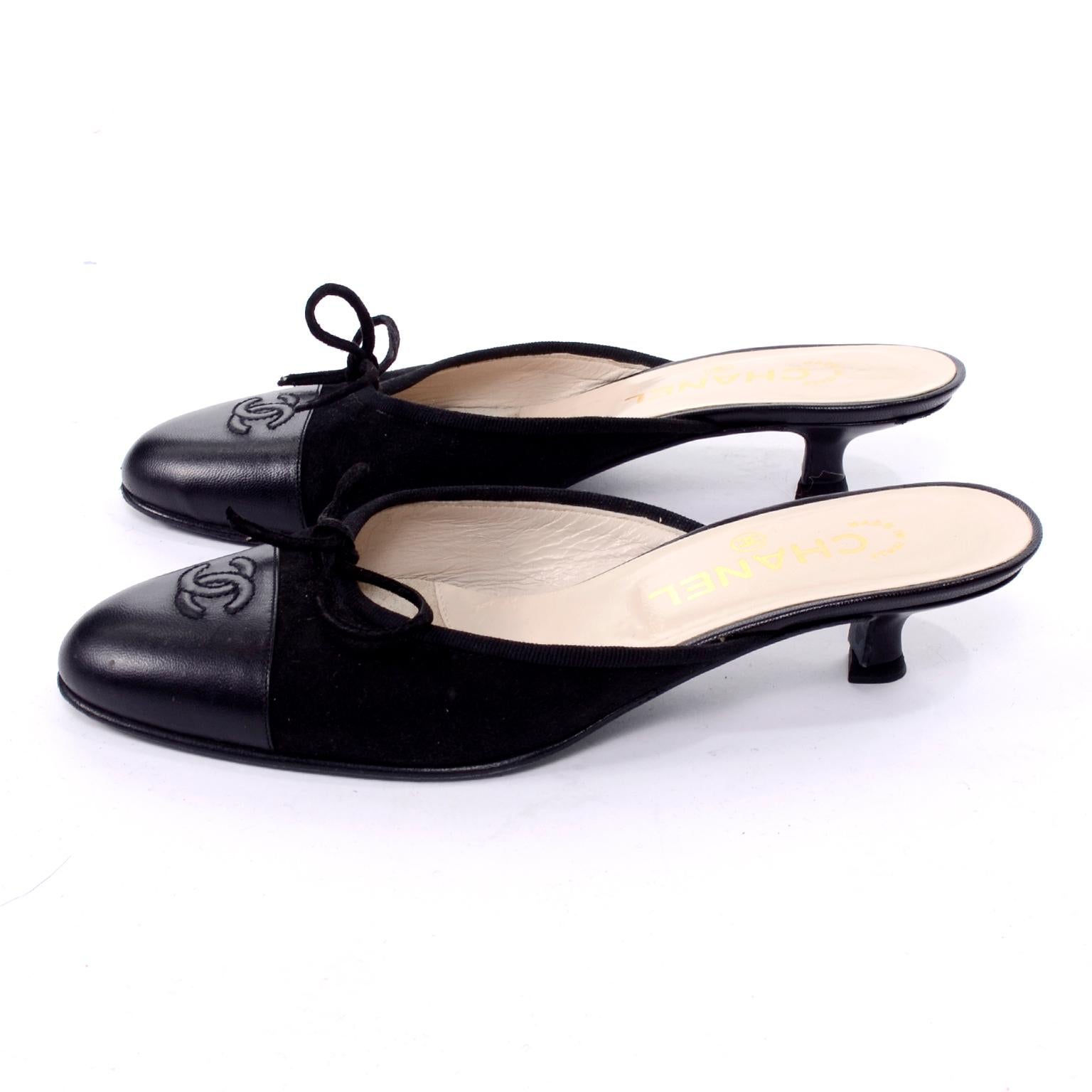 Chanel Black suede and smooth leather mules with bows and kitten heel. These shoes show the normal surface sole wear but are otherwise in good condition.  CC monogram logo is on the toe and they are labeled a size 36.