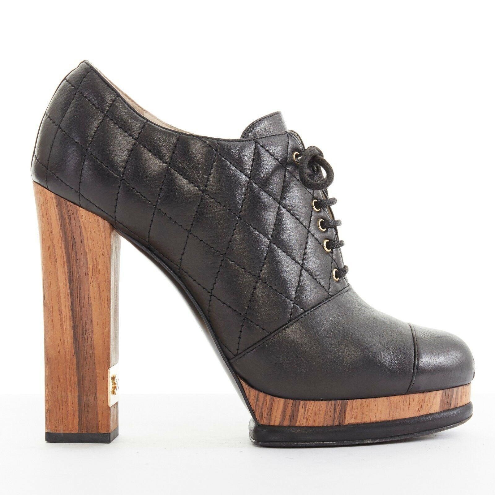 CHANEL black leather quilt stitched wooden platform CC chunky heel bootie EU39C

CHANEL
Black leather upper. Toe cap stitching. Quilt stitching on leather upper. Gold-tone metal grommet. Lace front closure. Natural wood and leather layered platform.