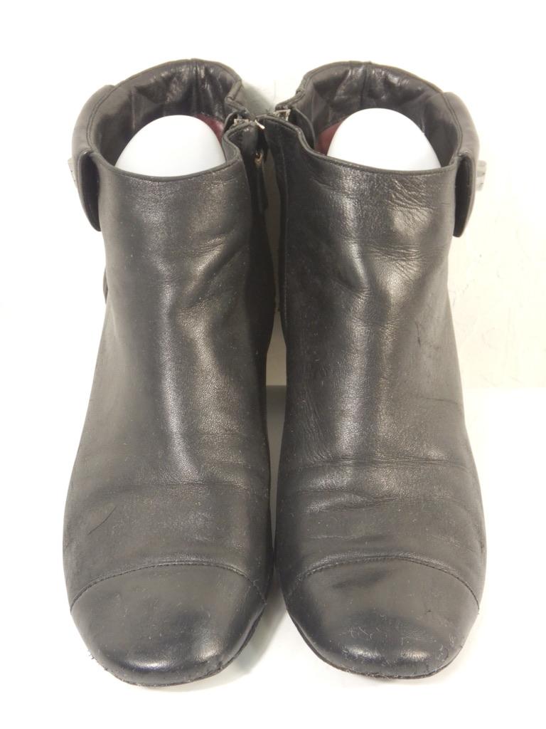 Chanel-Stiefelette aus schwarzem Leder mit dem ikonischen Steppmuster von Chanel und einem Chanel-Namensschild aus Metall im Turnlock-Stil. Das Drehschloss ist dekorativ, nicht funktional. Verschluss mit Reißverschluss.

Diese sind in einem guten