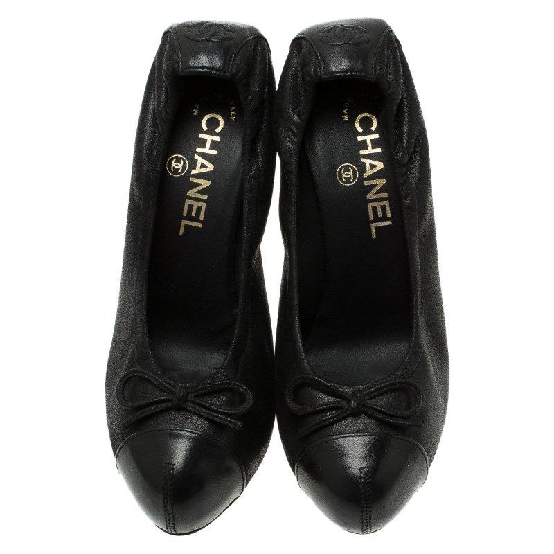 These classic Chanel pumps are noticed for their unique and timeless style. Crafted from black leather, they are accented with distinct cap toes, string bows on vamps, and scrunched counters with embossed CC logo. Elevated on 11 cm block heels,