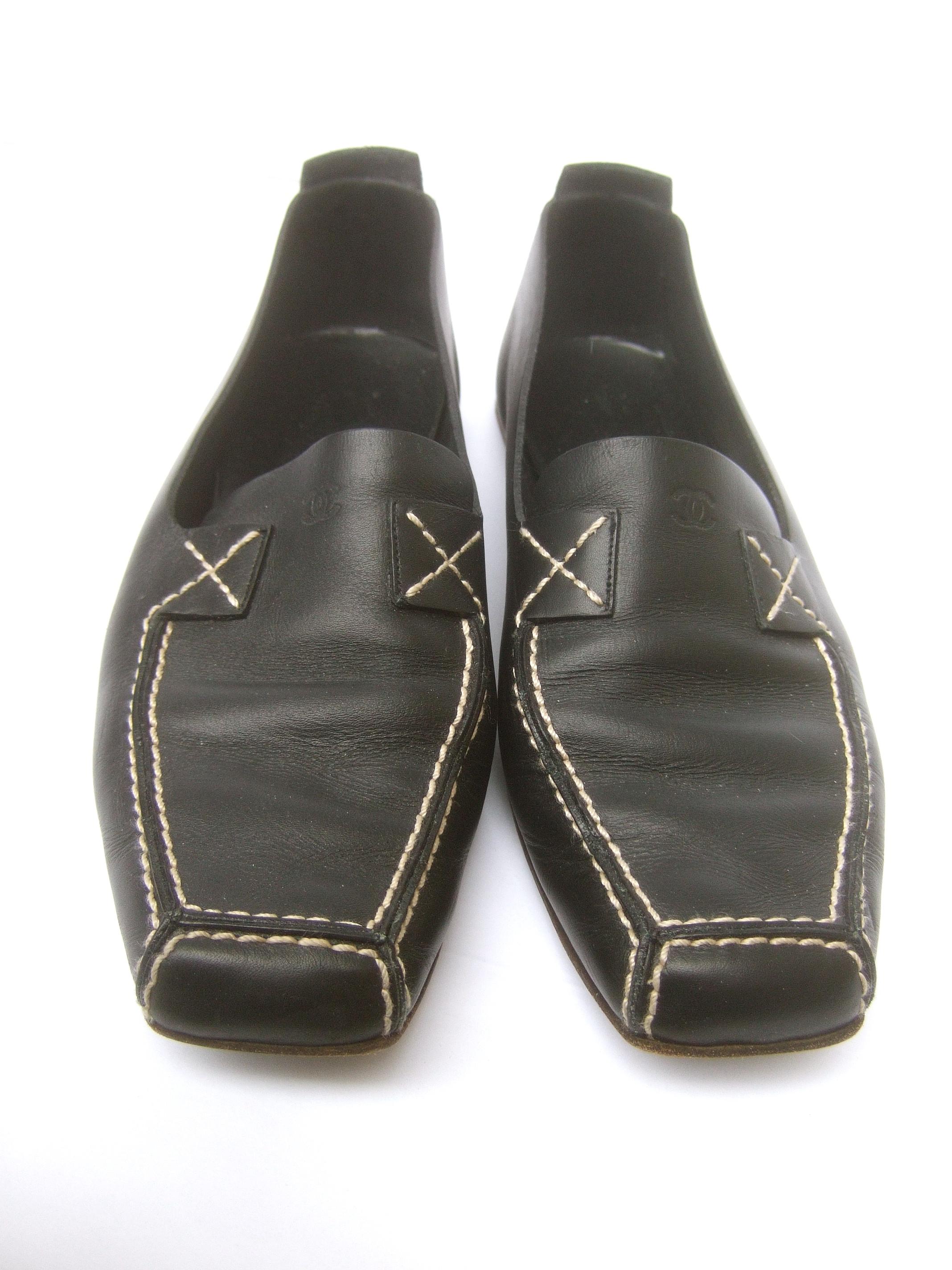 Chanel black leather slip-on Italian low heel flats Size 38.5 c 1990s
The stylish Italian flats are constructed with smooth black matte leather
designed with a square-shaped toe. Accented with white saddle stitching 

The back exterior heel is