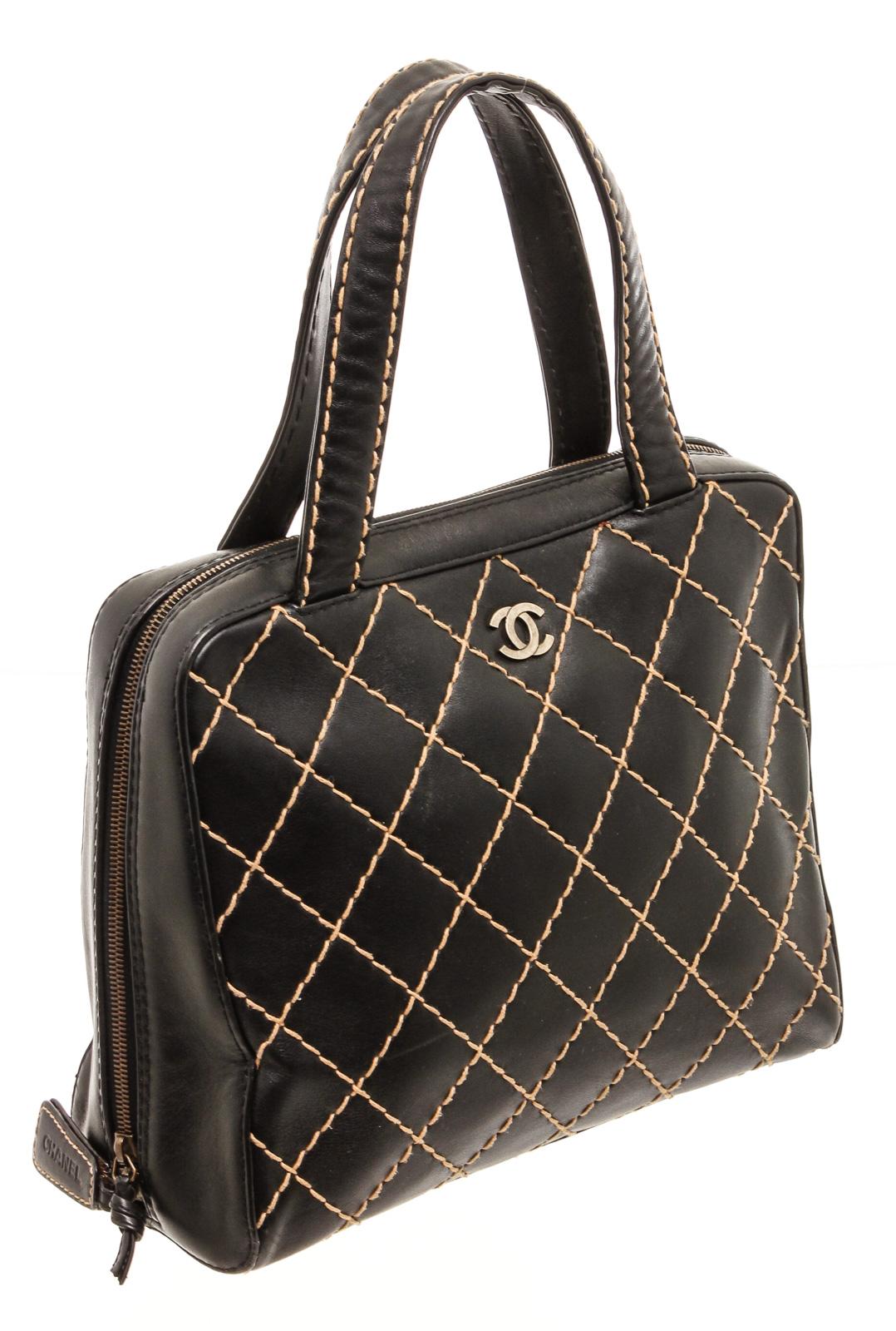 Black quilted leather Chanel Surpique Bowler bag with antiqued silver-tone hardware, dual flat shoulder straps, creme contrast stitching throughout, single slit pocket at back, tonal jacquard lining, three compartments at interior; one with zip