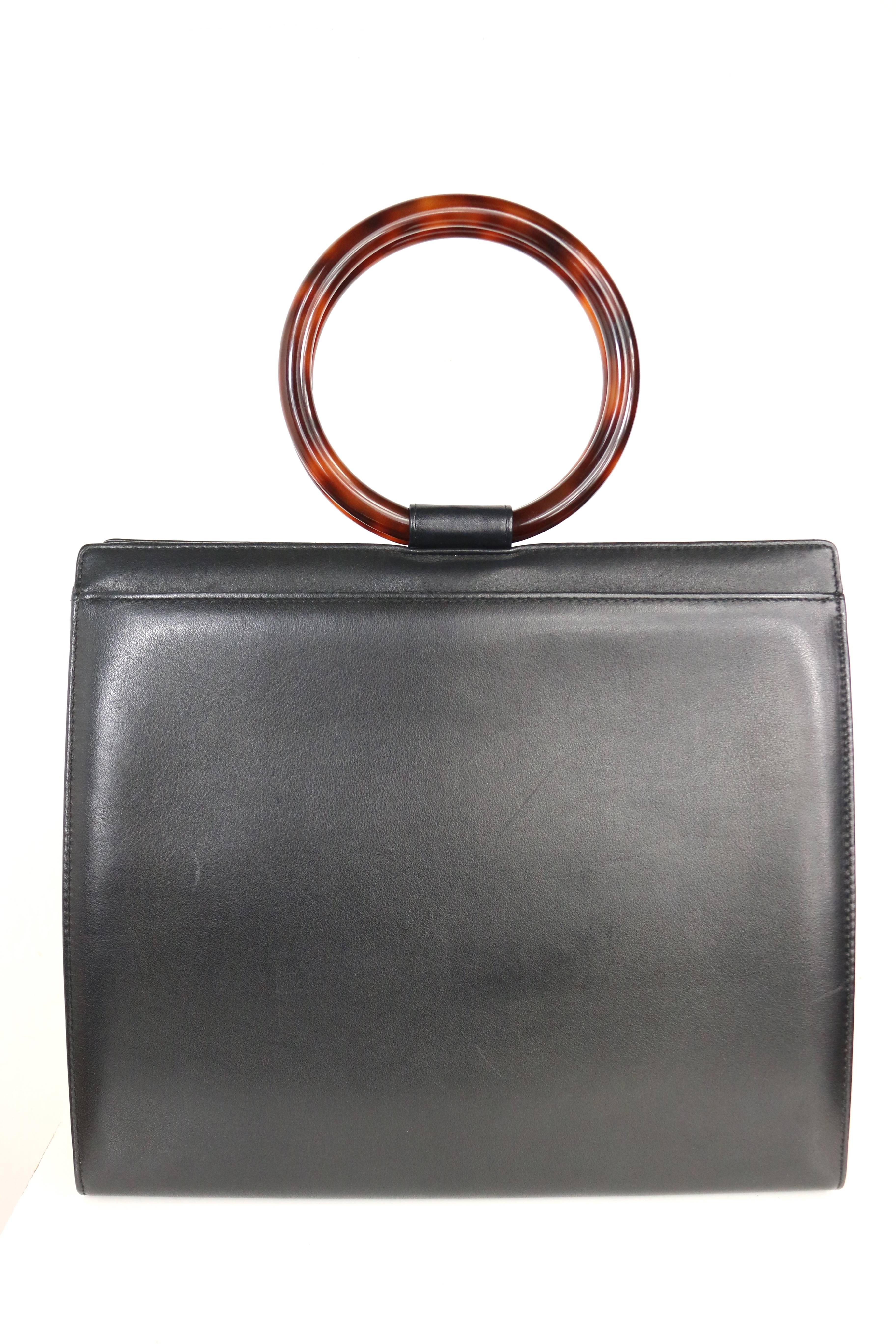 - Vintage 90s Chanel black leather with round shape tortoiseshell handle handbag. A very 60s retro style bag. 

- Featuring double tortoiseshell handles, one interior leather zipper pocket, and one interior slip pocket. 

- Made in Italy.   

-