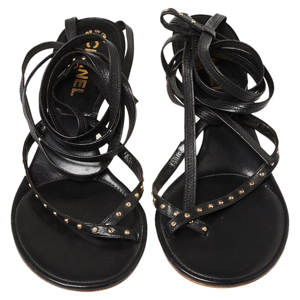 A feminine flair, sleek cuts, and a timeless appeal characterize these Chanel sandals. Crafted from leather in a black hue, they come with open-toes, slender straps of leather to be tied around the ankle, and are raised on low heels.

