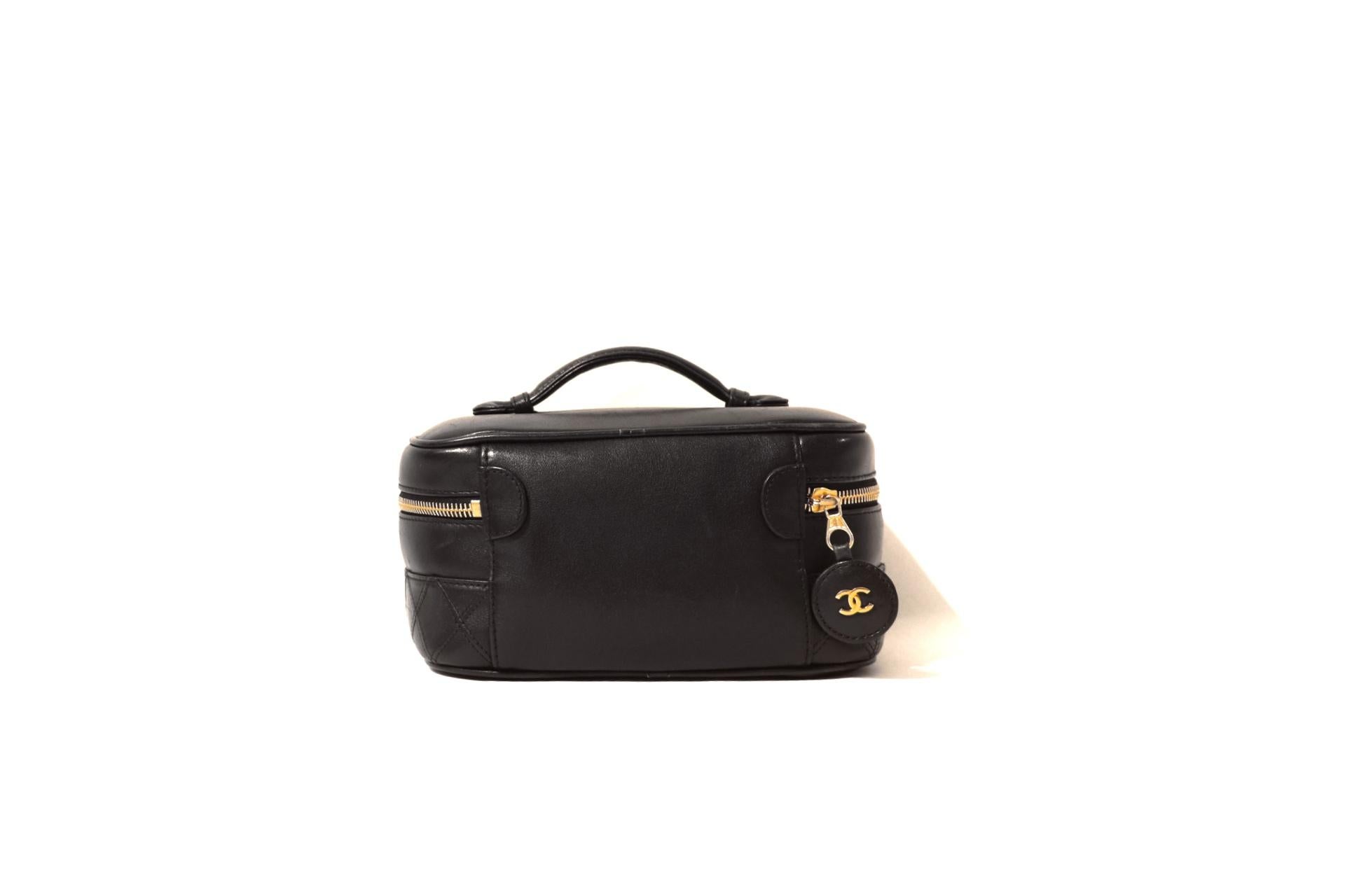 This authentic Chanel Vintage Black Leather Vanity Case is in truly mint condition.  From the mid 1990’s, this piece is a timeless addition to any collection.
Black leather top handle case has zip around closure with circular leather CC pull. Top