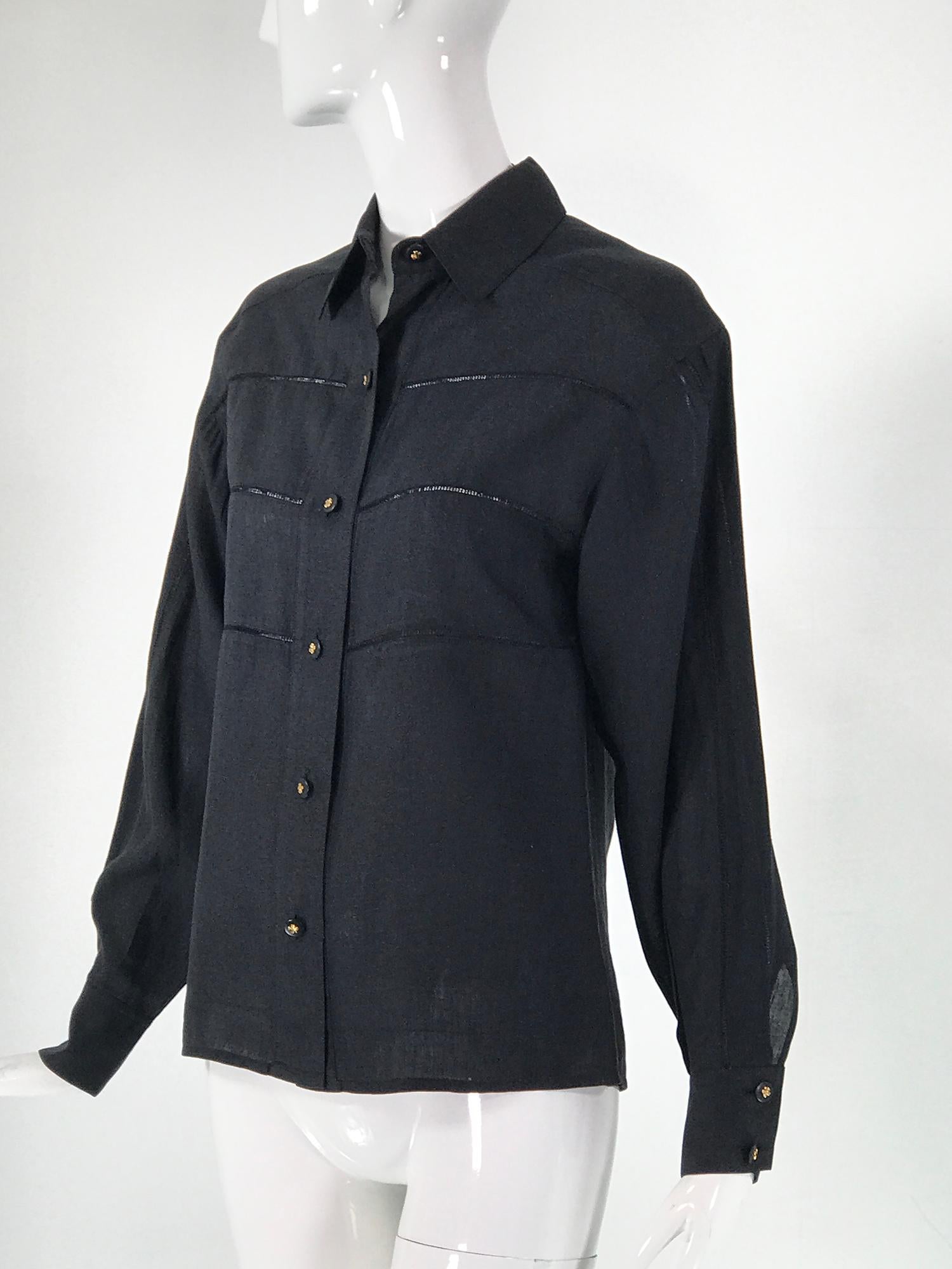 Chanel Black Linen Drawn Work Blouse. Long sleeve button front blouse with three rows of drawn work at each side front. Sleeves with drawn work down the center and double button cuffs. Yoke back with a single inverted pleat down the center. Chanel