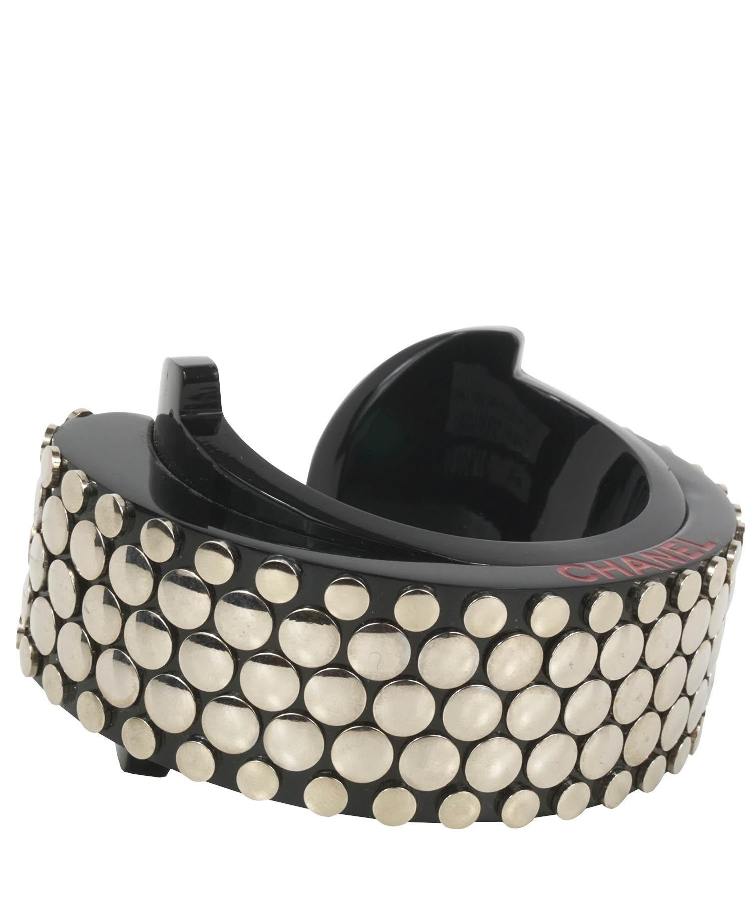Chanel vintage Perspex cuff bracelet, from their 2005 Collection, is featured in black resin with silver-tone nail heads throughout. Cuff has CHANEL etched into side perimeter. Cuff is wide and thick. Made in Italy. Cuff is in excellent condition