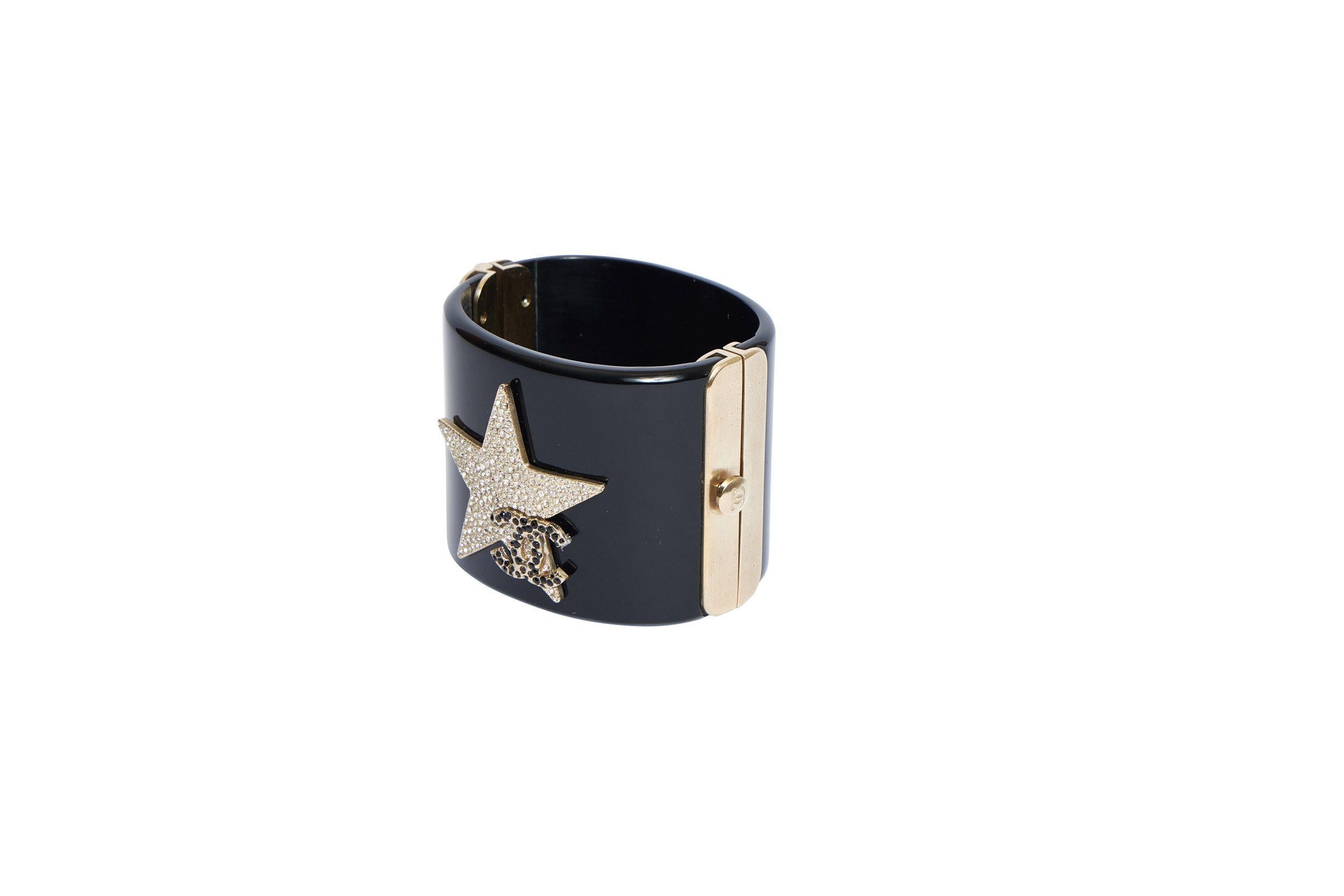 Hermes vintage black lucite cuff bracelet. Star with gold and clear rhinestones and black rhinestones CC logo. Gold plated metal hardware. Comes with original box.