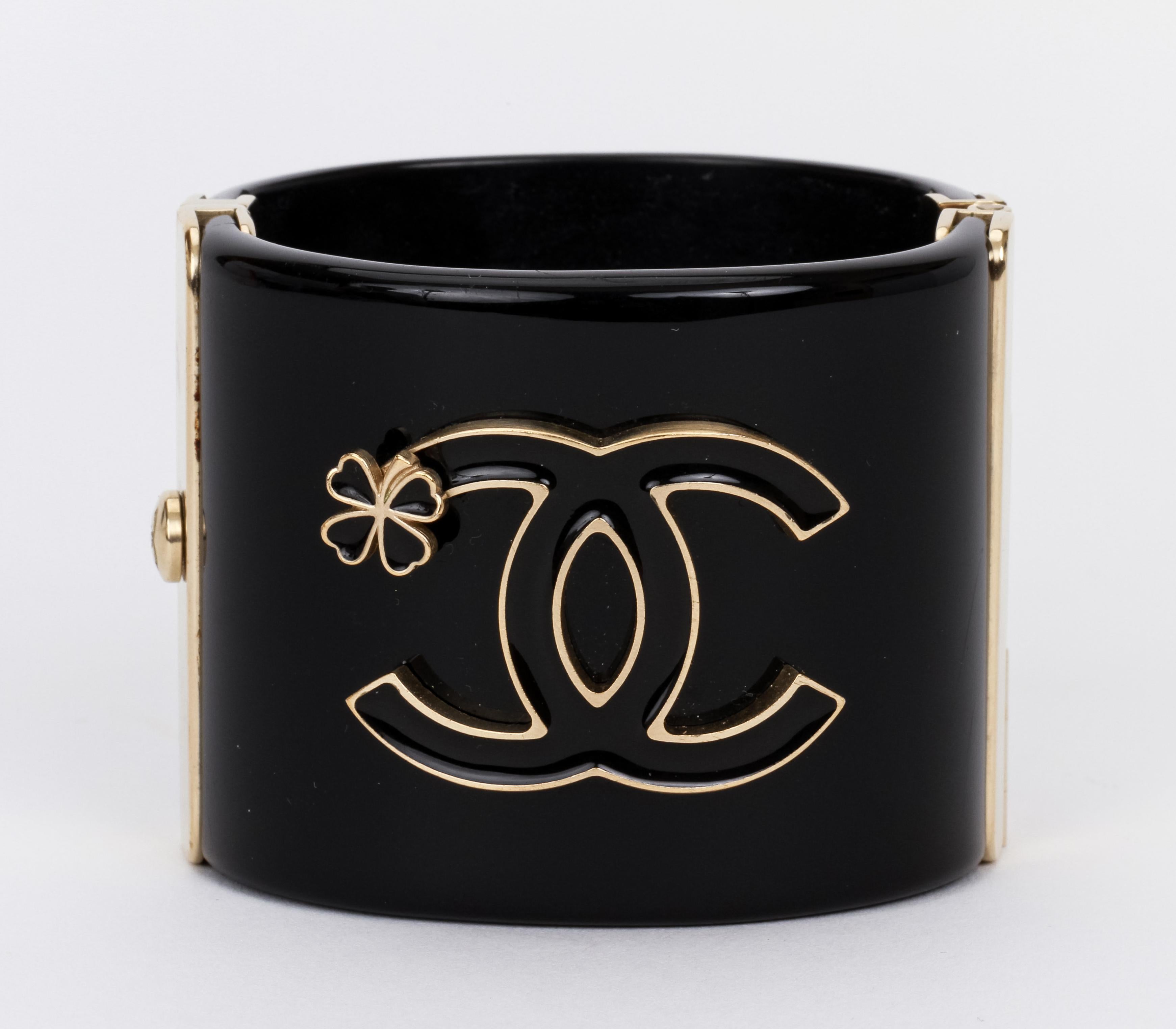 Importante bracciale ovale con cerniera in lucite nera di Chanel, logo CC con trifoglio. Viene fornito con la scatola originale.
