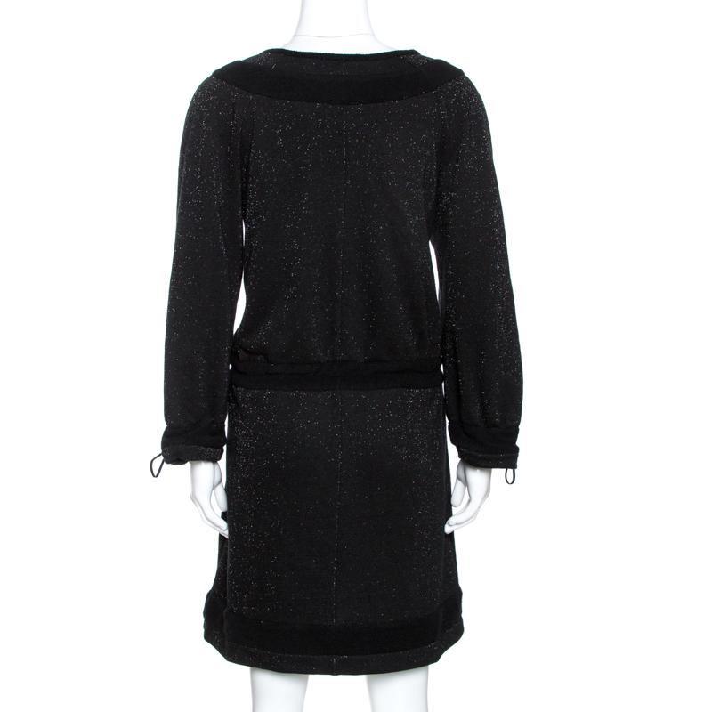Grab this stylish and cool dress by Chanel for fun outings with friends. Crafted from cotton, it comes in black and features lurex. It is styled with long sleeves, round neck, front zip closure, drawstring detailing around the waist and sleeves. It