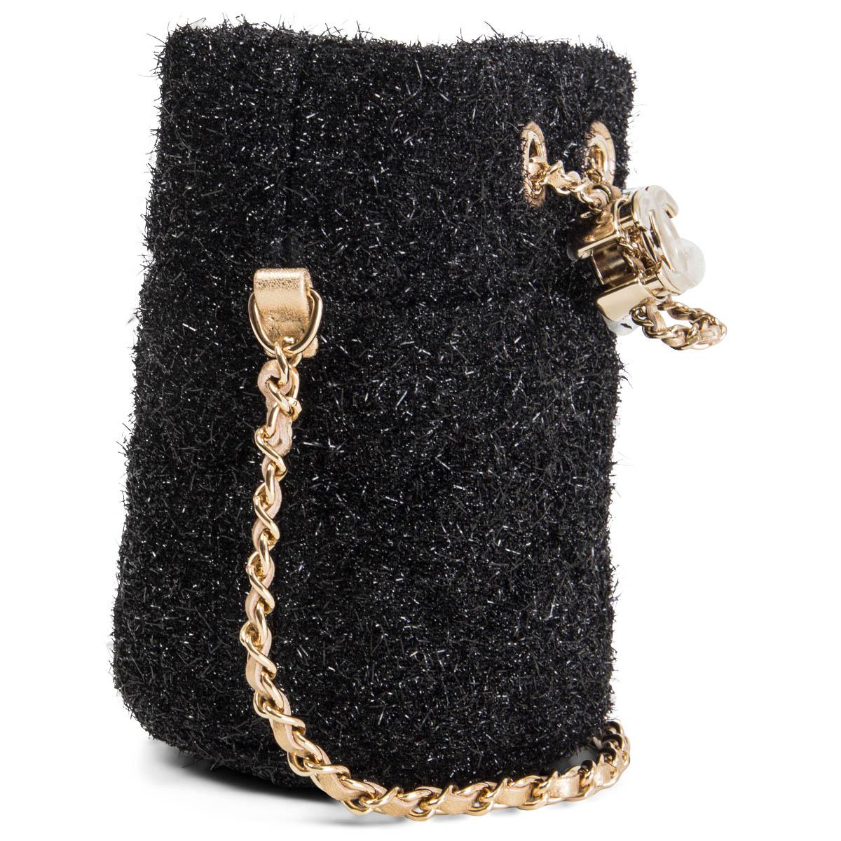 100% authentic Chanel mini bucket bag with chain in black metallized fibers and cotton tweed. 2021 VIP gift. Opens with the signature CC logo drawstring closure and is lined in gold leather and beige canvas. Has been worn once and is in virtually