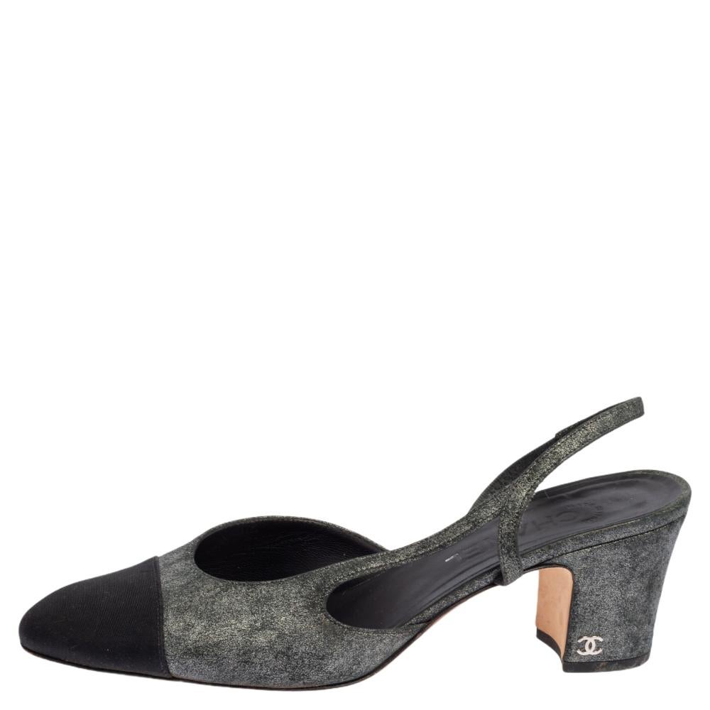 An iconic design by Chanel is this stunning slingback pair! These metallic grey & black sandals are crafted from suede and come with contrasting fabric cap toes. They flaunt slingbacks, leather-lined insoles, and block heels that carry the signature