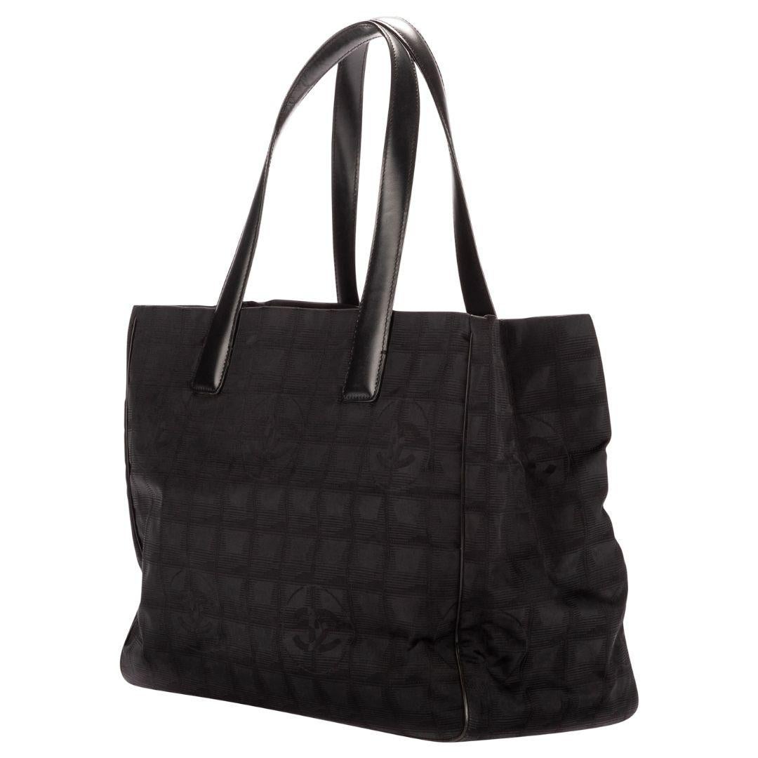 The black canvas variant of the Travel Ligne tote with gold hardware, an open top, and a nylon interior that includes two zippered pockets.

SPECIFICS
Length: 14.2
Width: 5.9
Height: 10.6
Strap drop: 7.1
Authenticity code: 7594578 (2002-2003)
Comes
