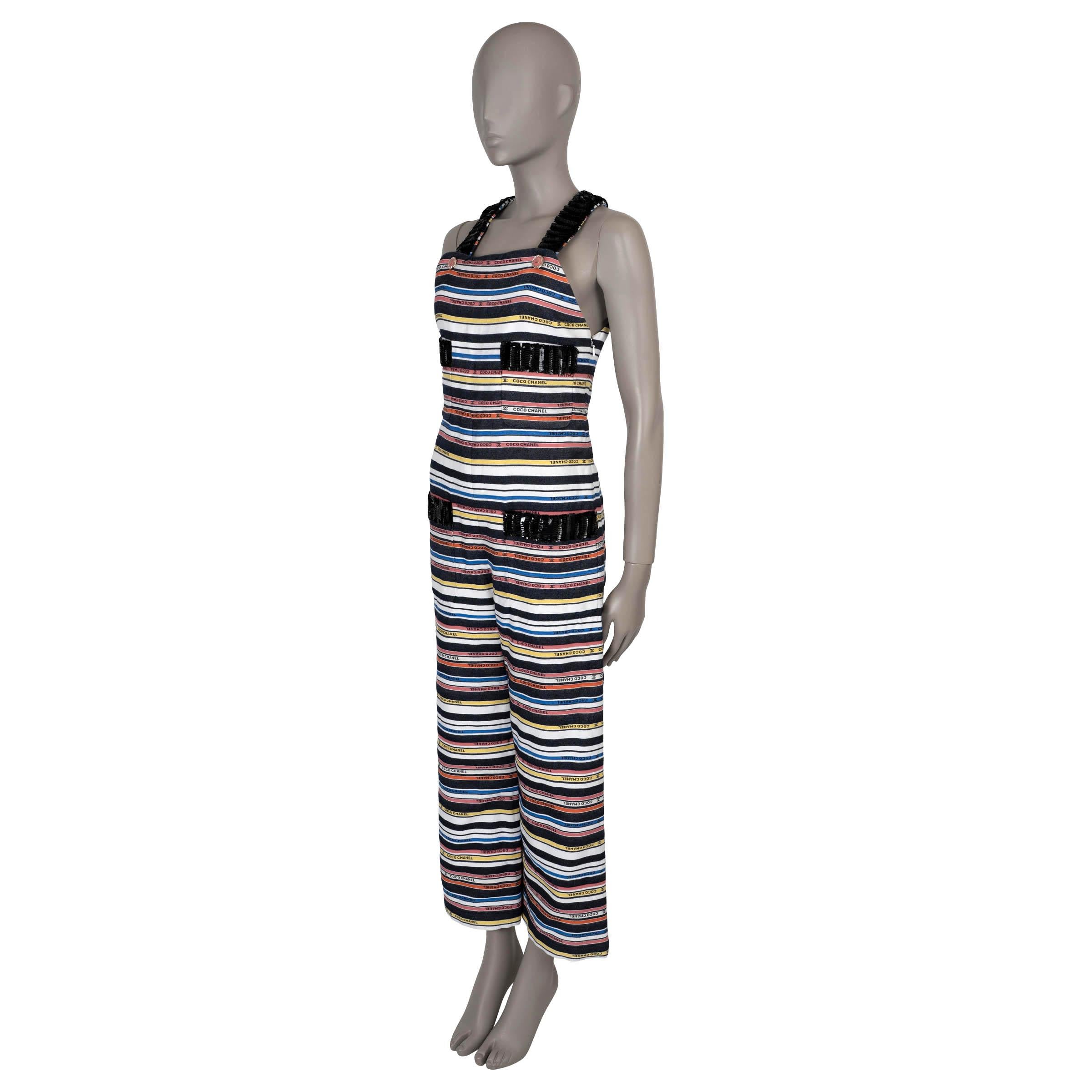 This 100% authentic Chanel jumpsuit in vibrant striped jacquard cotton features black, white, yellow, blue, coral, and red stripes with Chanel lettering and CC logos woven throughout for an iconic touch. Designed with a sleeveless, relaxed