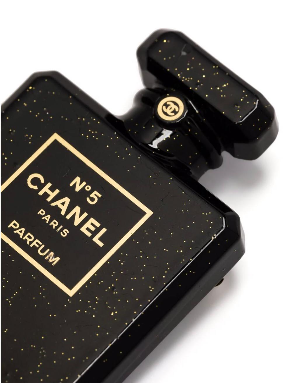 Black Chanel brooch featuring a black and gold-tone colours, a signature N°5 motif, perfume bottle motif, a black top logo medal, a logo plaque at back and a safety pin.
Circa: 2021
Width: 1.25in. (3.5cm) 
Maxi Length:1.9in. (5cm)
In good vintage