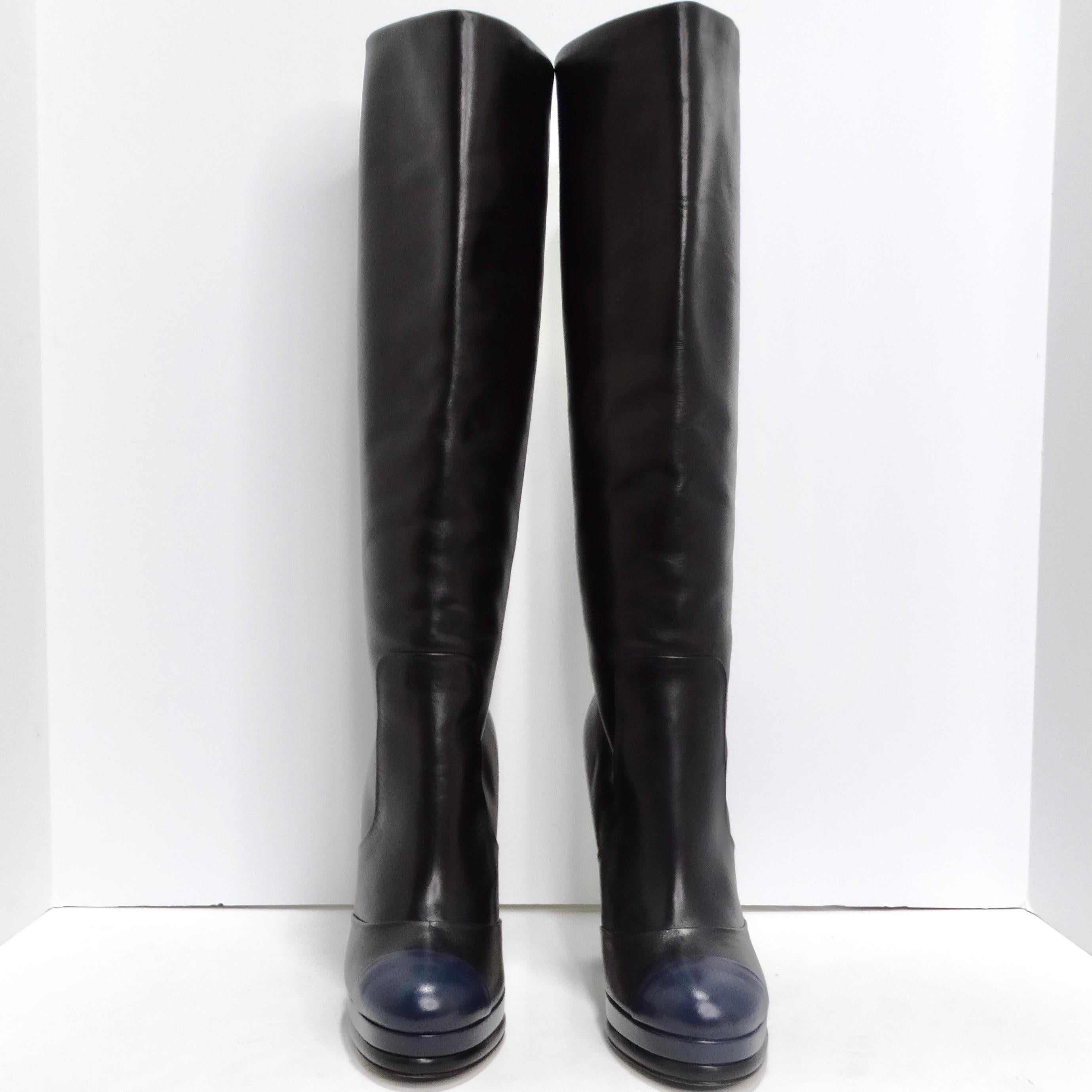 Der Inbegriff von Luxus und Stil mit diesen Chanel Black/Navy Blue Leather CC Boots. Diese mit viel Liebe zum Detail gefertigten, kniehohen Stiefel sind ein Beweis für das ikonische Design und die unvergleichliche Handwerkskunst von Chanel. Die