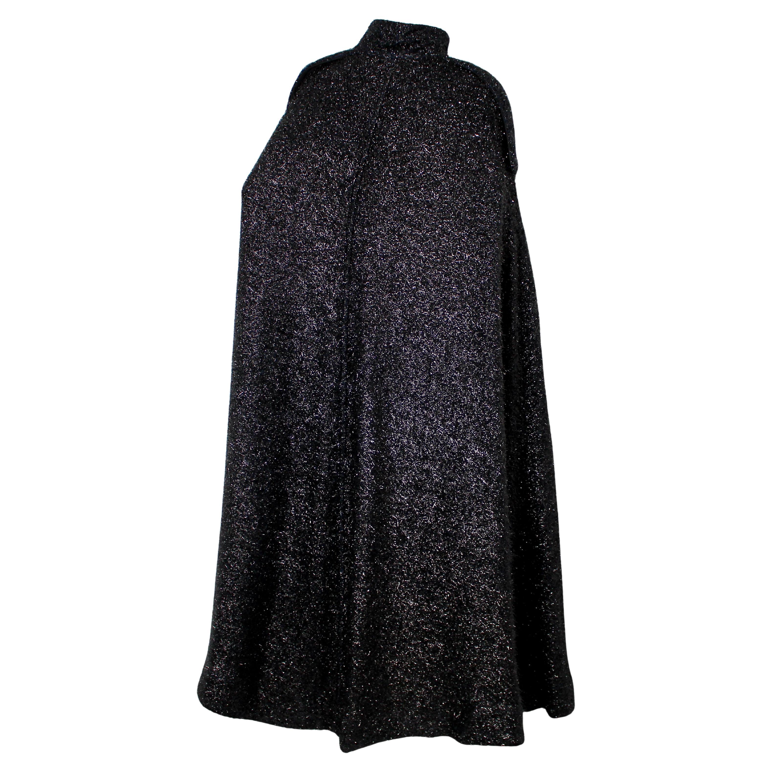 La mantella Chanel in misto lana metallizzata nera e marina del 2019 è un pezzo straordinario che combina perfettamente lusso ed eleganza moderna. Realizzata in misto lana, la mantella è caratterizzata da una sofisticata palette di nero e blu