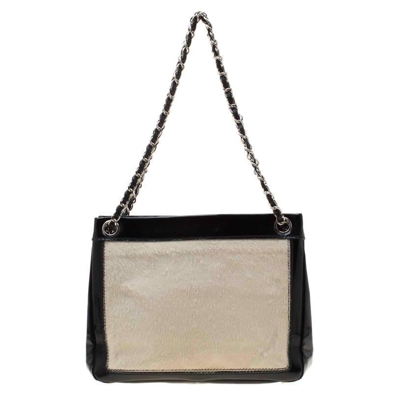 Give yourself a luxurious look with this pony hair and patent leather bag that is stylish and functional. This beauty comes with a well-sized fabric interior that features a small zip pocket and adequate space to house your essentials comfortably.