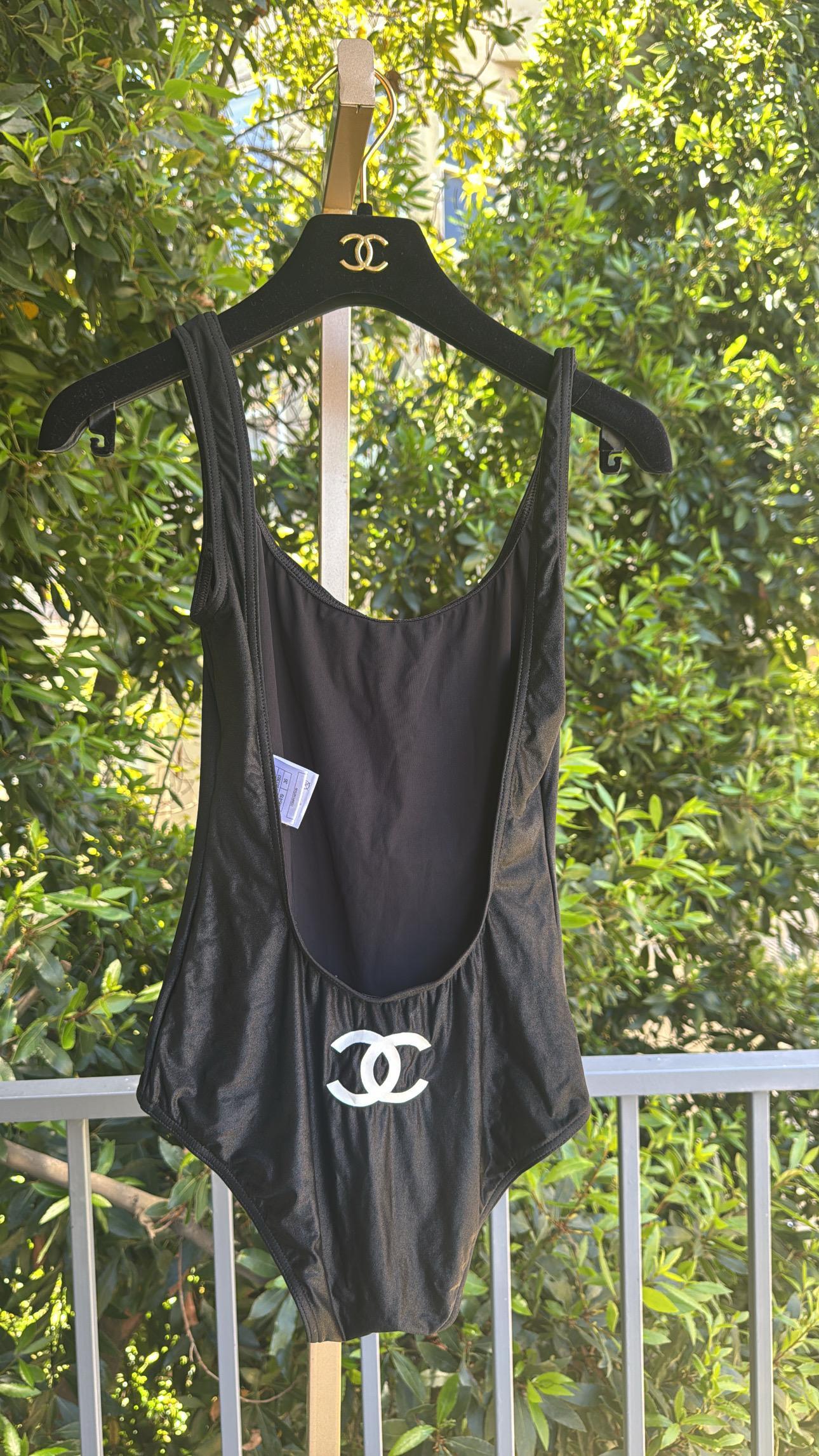 Traje de baño de una pieza CHANEL en negro de la colección 2009. 

Presenta un escote profundo en la espalda y un llamativo logotipo CC blanco en la parte delantera. 

No hay defectos significativos que señalar. 
Talla 36.