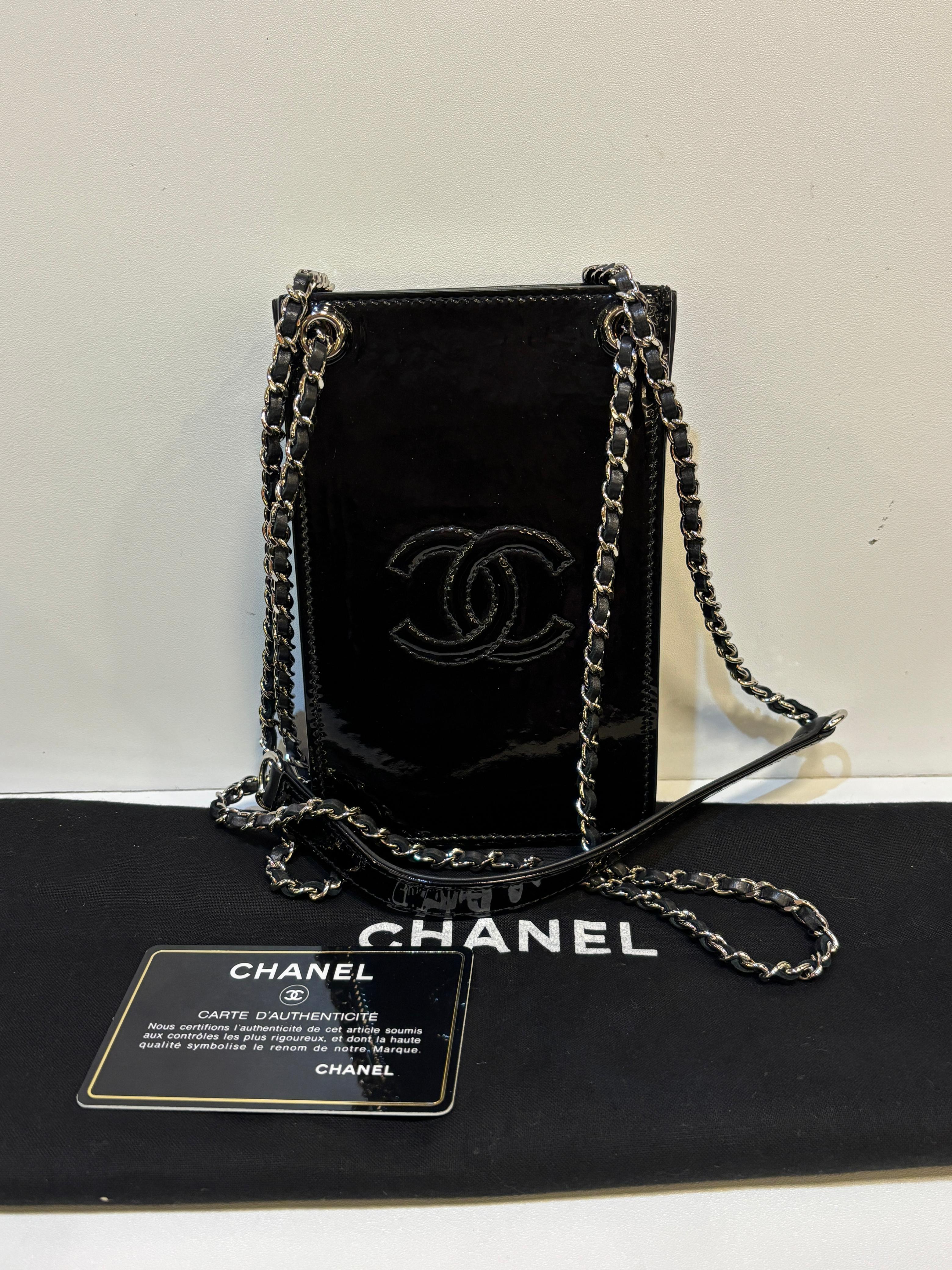 Chanel mini phone holder in black patent. Can be worn crossbody or shoulder. In very good condition, only minor wrinkling and minor dent on the backside. Series #20. Comes with holo, card and dust bag.