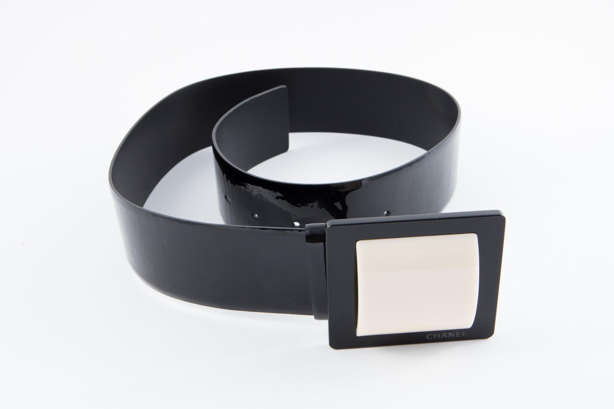 Gorgeous black patent lamb leather Chanel belt featuring an ivory and black large buckle, pitted Chanel on front buckle, and an adjustable buckle. 
Width: 1.9in. (5cm)
Length: 35,4in. (90cm)
In excellent vintage condition. Made in France.
We