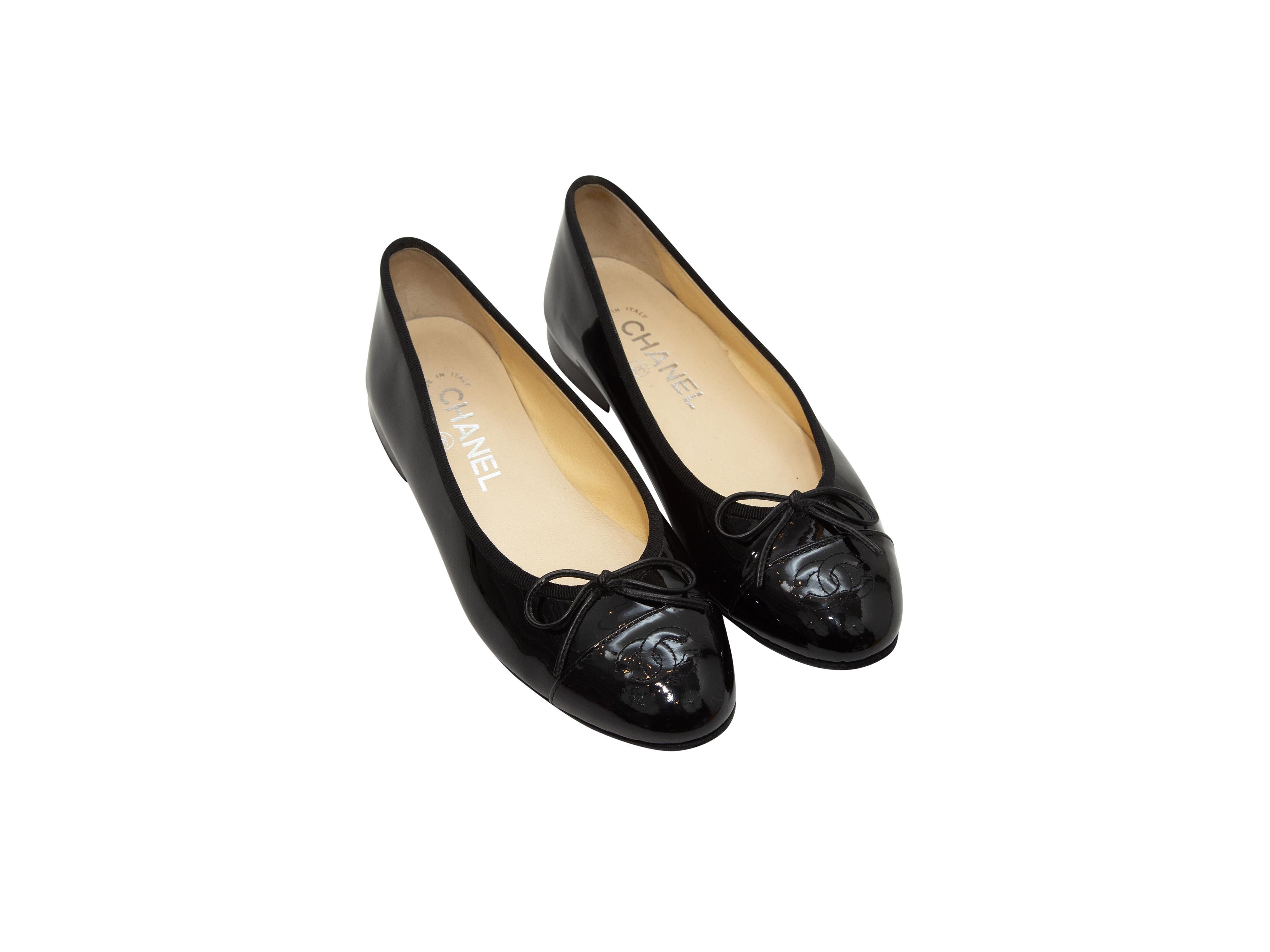 Product details: Black patent leather cap-toe ballet flats by Chanel. CC stitching and bow accents at toes. Stacked heels. Designer size 36. 0.5