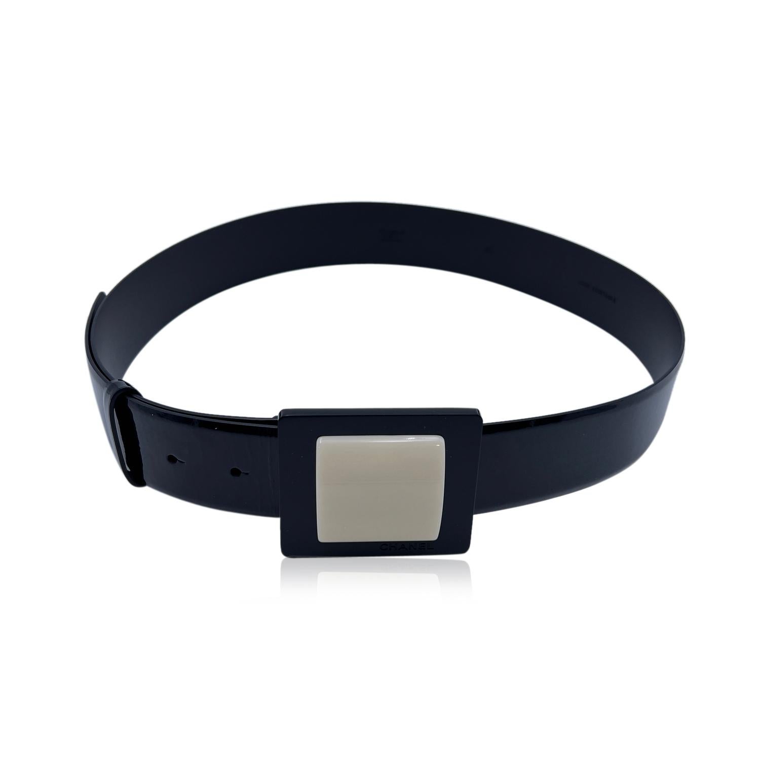 CHANEL black patent leather belt with white squared buckle. 'Chanel - 07 CC A - Made in Italy' engraved on the reverse of the belt. Size 40. Width: 1.6 inches - 4 cm. Total length of the strap: 36.5 inches - 91.5 cm. From buckle to first notch (max.