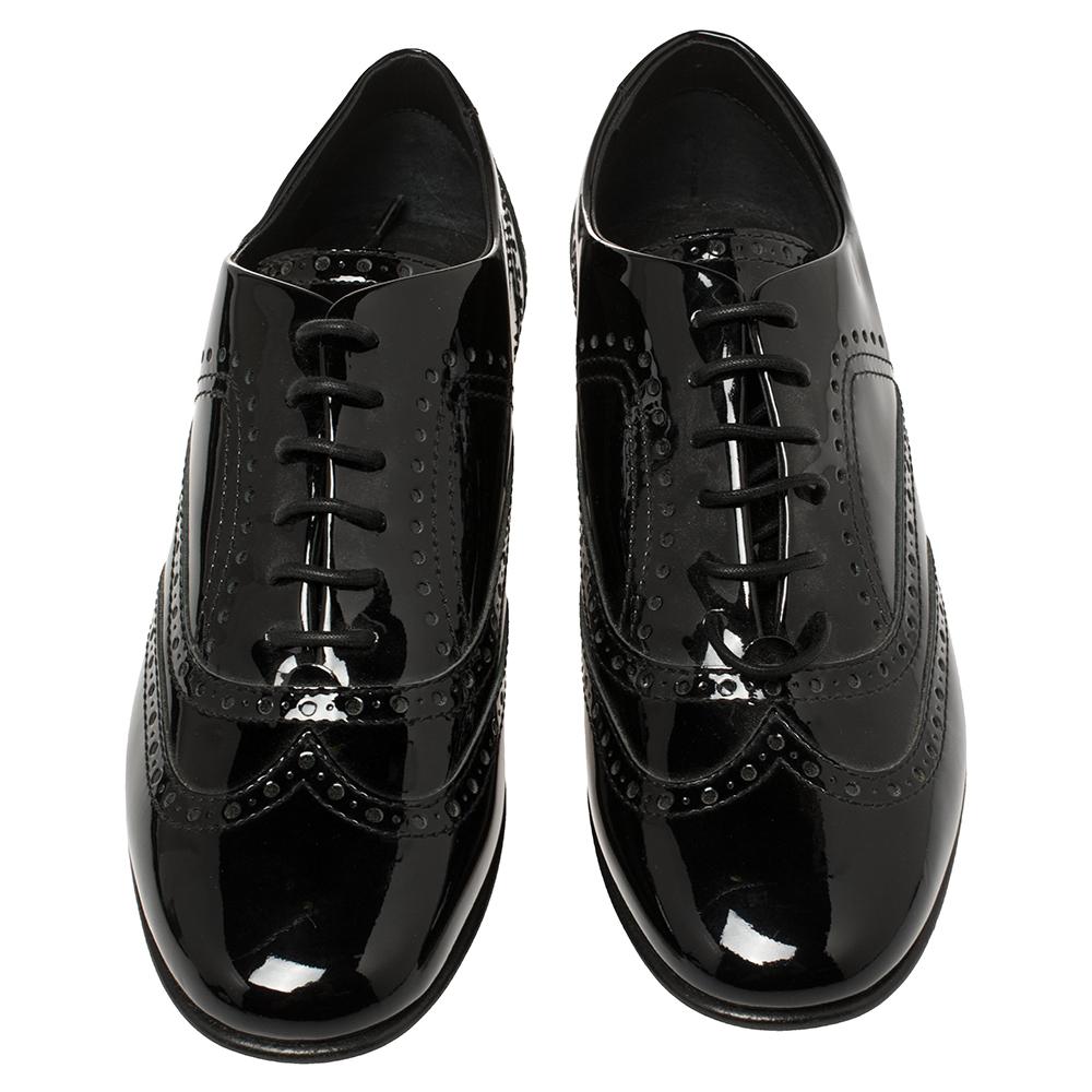 These fashionable oxfords from Chanel are a must-have for the modern woman. They are crafted from black brogue patent leather and styled with lace-ups on the vamps. They'll offer you comfort with their leather-lined insoles and will look great with