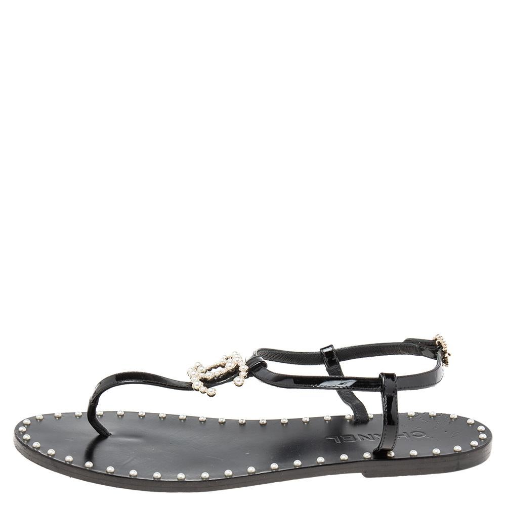 This season, give the Chanel touch to your outfit by choosing these sandals. Crafted from black patent leather, this pair features a thong design and buckle fastening at the ankles. The pair is complete with an embellished CC logo on the uppers and