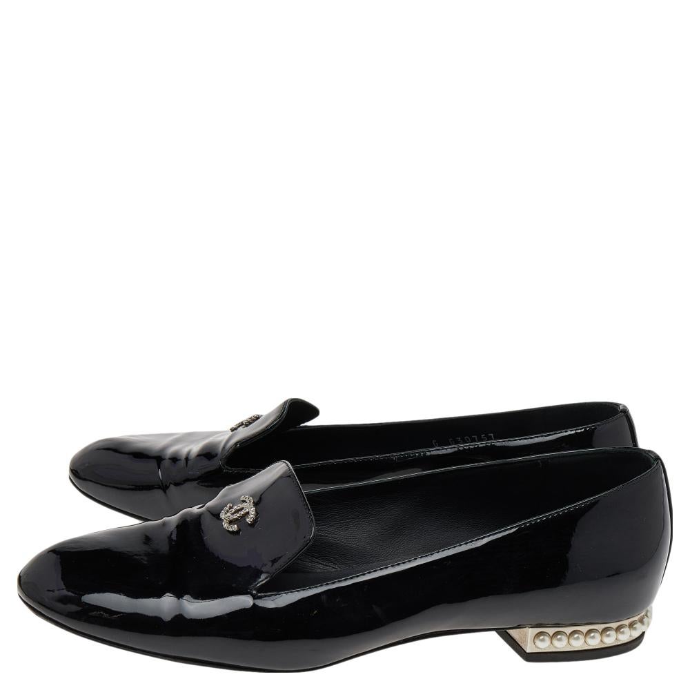 These Chanel loafers are a great alternative to those regular heels. Exclusively crafted in a black patent leather body, these loafers feature the iconic 'CC' logo on the front and pearl-embellished heels. Easy to slip on and off, these loafers will