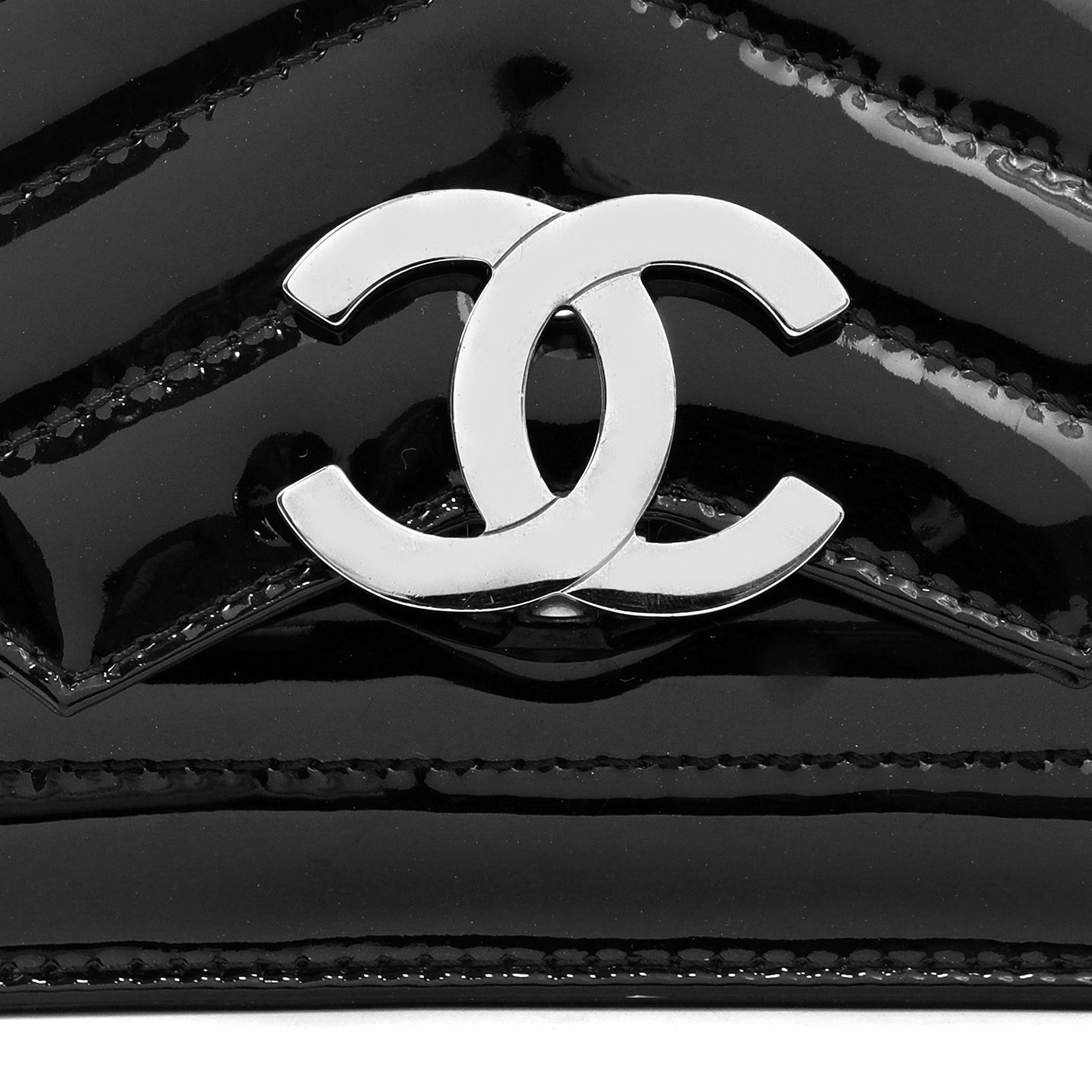 This authentic Chanel Black Patent Leather Chevron Mini CC Crossbody Bag is in pristine condition.  An updated classic with oversized silver CC clasp and chevron quilting.  Leather and chain entwined strap may be carried single, double, or cross the