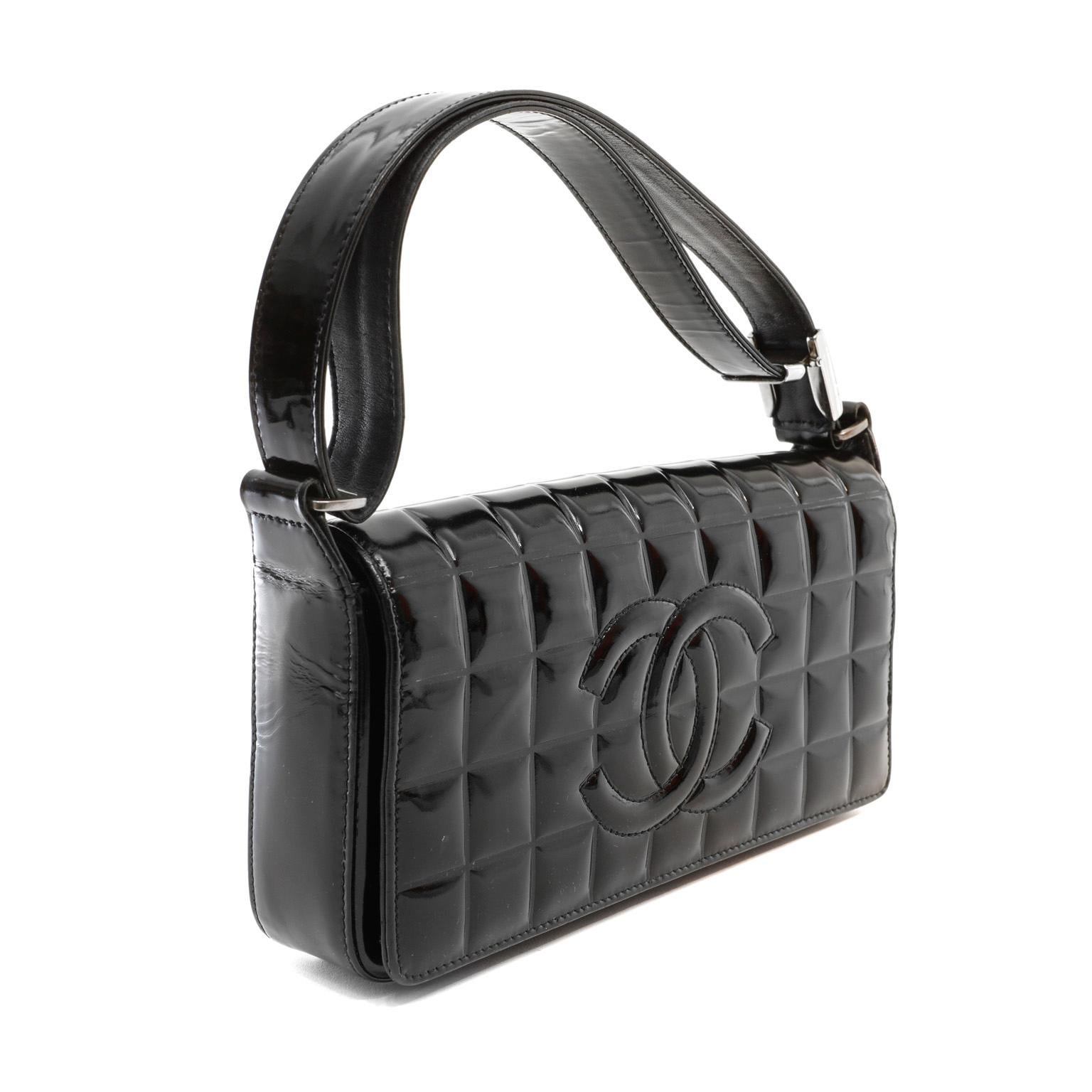 This authentic Chanel Black Patent Leather Chocolate Bar Quilted CC Shoulder Bag is in mint condition.  Weather friendly black patent leather is quilted in square chocolate bar pattern.  Large tonal interlocking CC is stitched on the front flap. 