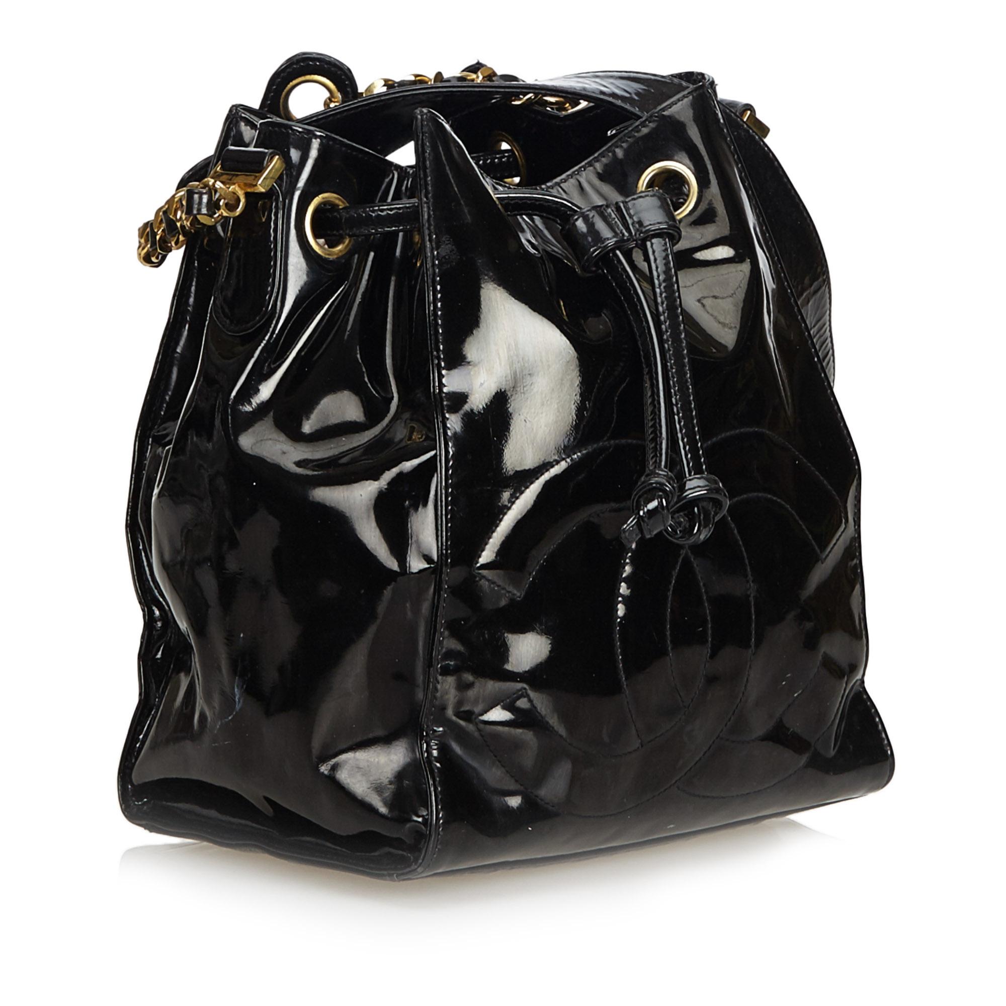 This bucket bag features a patent leather body, flat leather shoulder strap, and an open top with drawstring closure. It carries as B condition rating.

Inclusions: 
Authenticity Card
Pouch

Dimensions:
Length: 24.00 cm
Width: 22.00 cm
Depth: 16.00