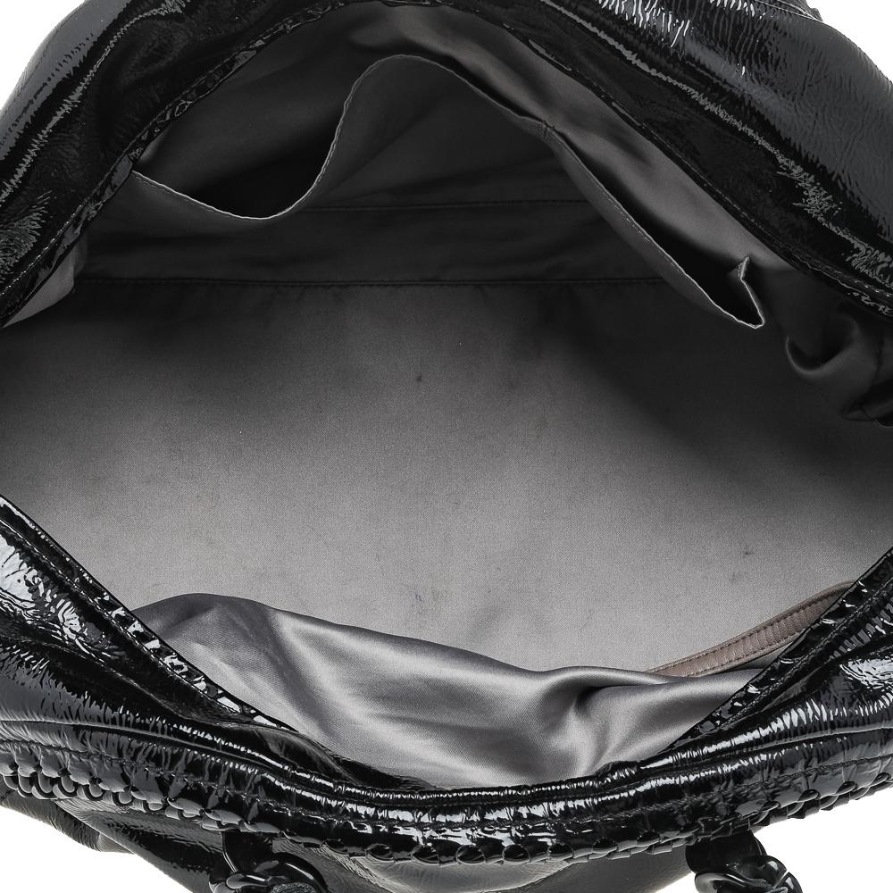 This Luxe Ligne Bowler bag is a classy creation by Chanel. It features a chain-detailed patent leather exterior in black with the CC logo on the front and two chain handles on top. The zip opens up to a satin-lined interior.

Includes: Original
