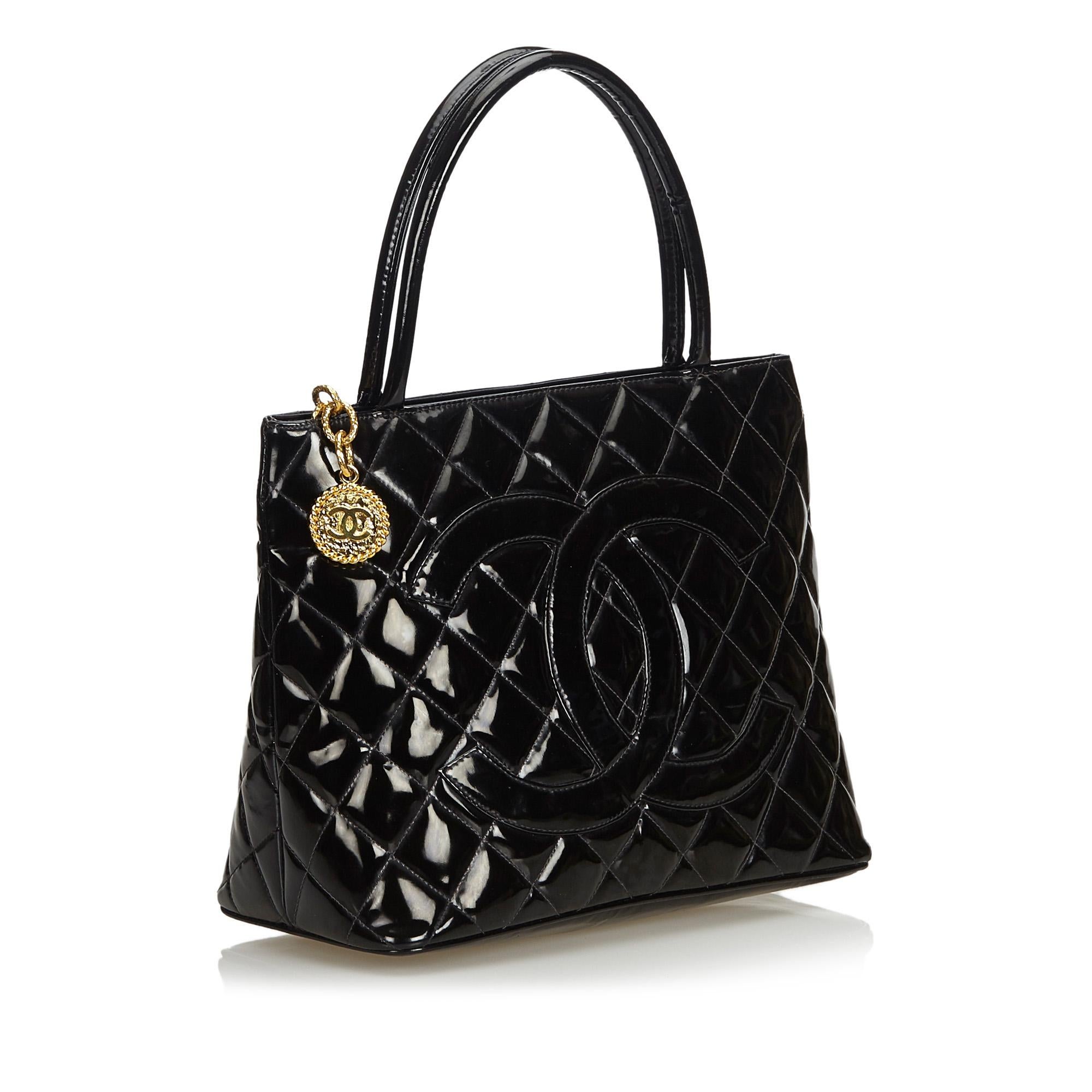The Medallion tote features a quilted patent leather body, rolled leather handles, a top zip closure, exterior back slip pocket, and an interior zip pocket. It carries as B+ condition rating.

Inclusions: 
This item does not come with