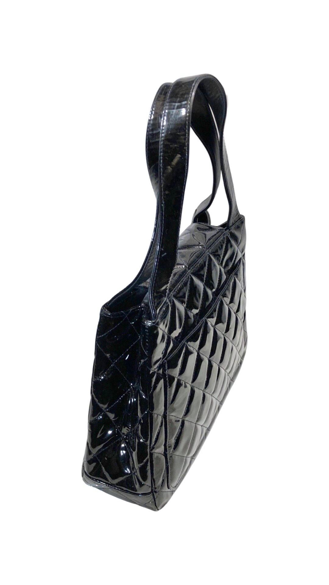 - Bolso bandolera/de mano vintage Chanel de charol negro acolchado con solapa.

- Solapa de cierre giratorio con herrajes plateados 