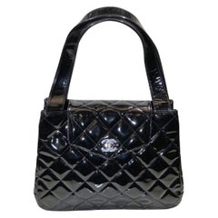 Chanel Borsa a tracolla con patta in vernice nera trapuntata in argento "CC" via