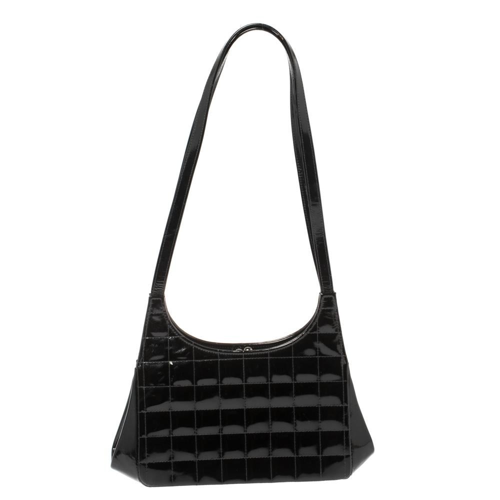 Crafted in black-hued patent leather, this must-have vintage piece from Chanel is sure to make a standout addition to your collection. The bag features a stitched CC logo in the front, two flat long leather shoulder straps, and a Kisslock closure.