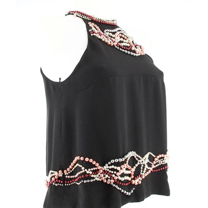 Chanel black pearl top

Good condition, shows slight traces of wear over time.
100% silk top, can be worn in summer but also in winter.
Several pearls of different colours are inserted in the top. The material is smooth and pleasant to the