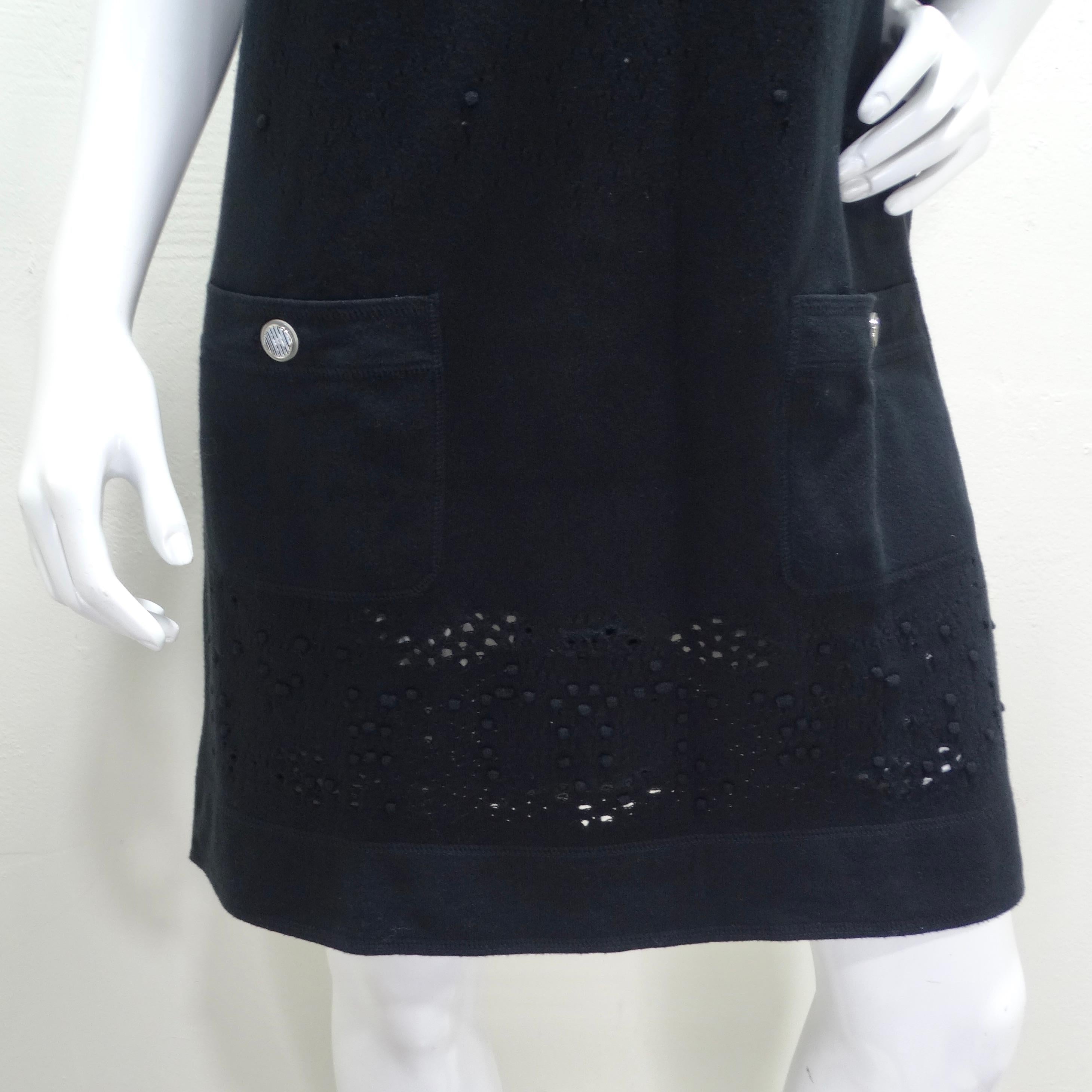 La robe à manches courtes en maille perforée noire de Chanel est un parfait mélange d'élégance classique et de savoir-faire moderne, reflétant l'esthétique emblématique de Chanel avec une touche contemporaine. Cette mini-robe à manches courtes se